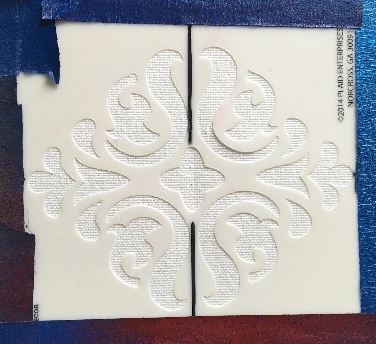 step 1 - Outer Bag Iron medium weight interfacing to the wrong side of the white panels. Mark the center of the stencil. Spray it with adhesive and center it on the right side of the white panel.