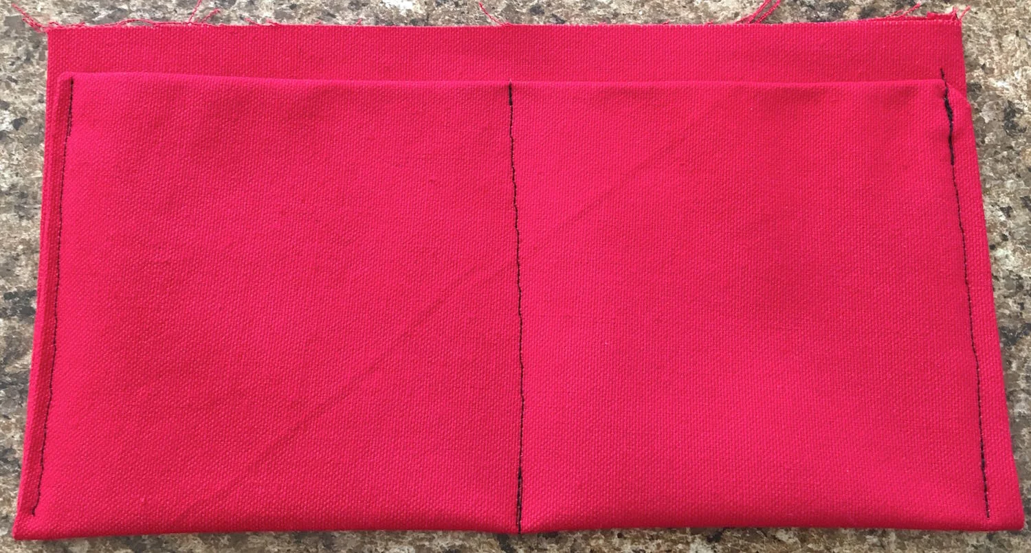step 14 - Top stitch the sides through all thicknesses close to the edge. Sew a row of stitching up the center to create two pocket spaces