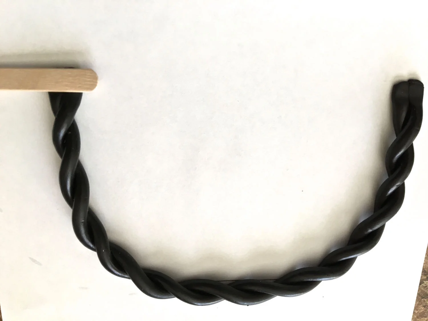 step 20 - Press a craft stick to both edges of the clay to reduce the thickness and flatten it.