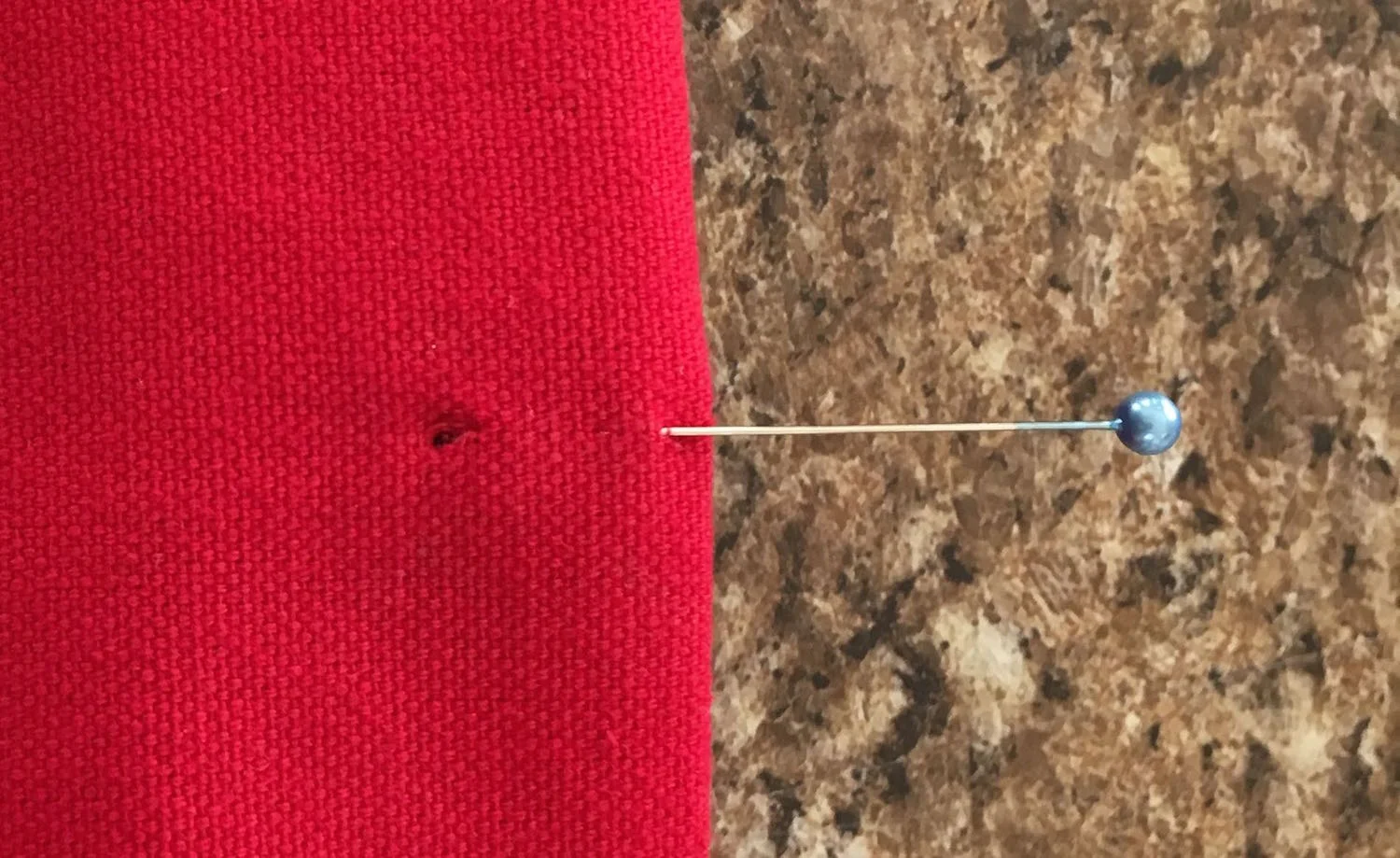 step 29 - With a craft knife, create four holes in all layers of the bag's top edge to attach the tabs. Use the pins as guides for placement. Insert brads into the holes in the clay tabs, then through the holes in the fabric. Secure the brad prongs on the facing.