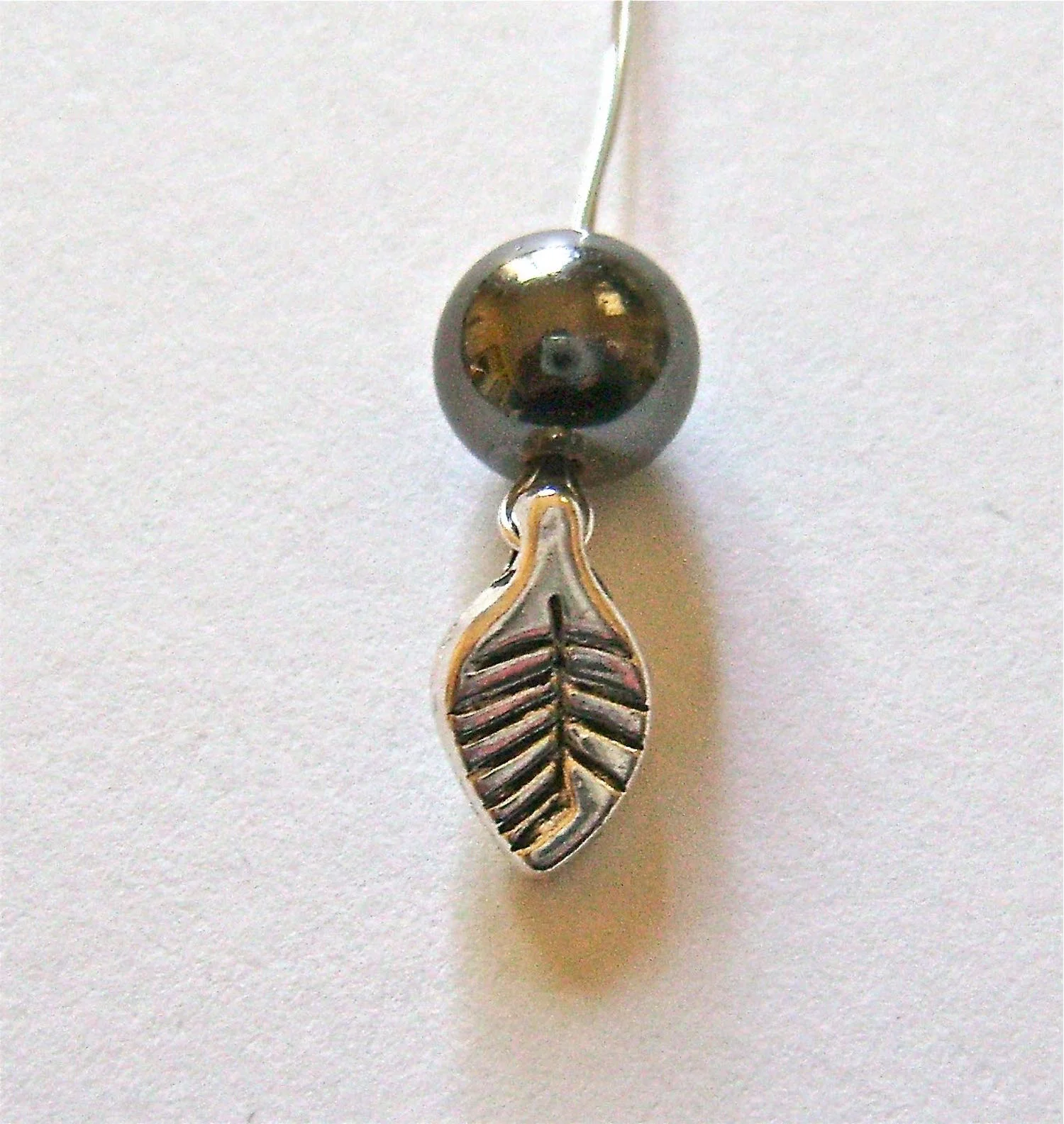 step 3 - Slip a pearl over both ends of the wire and push it down to the leaf.