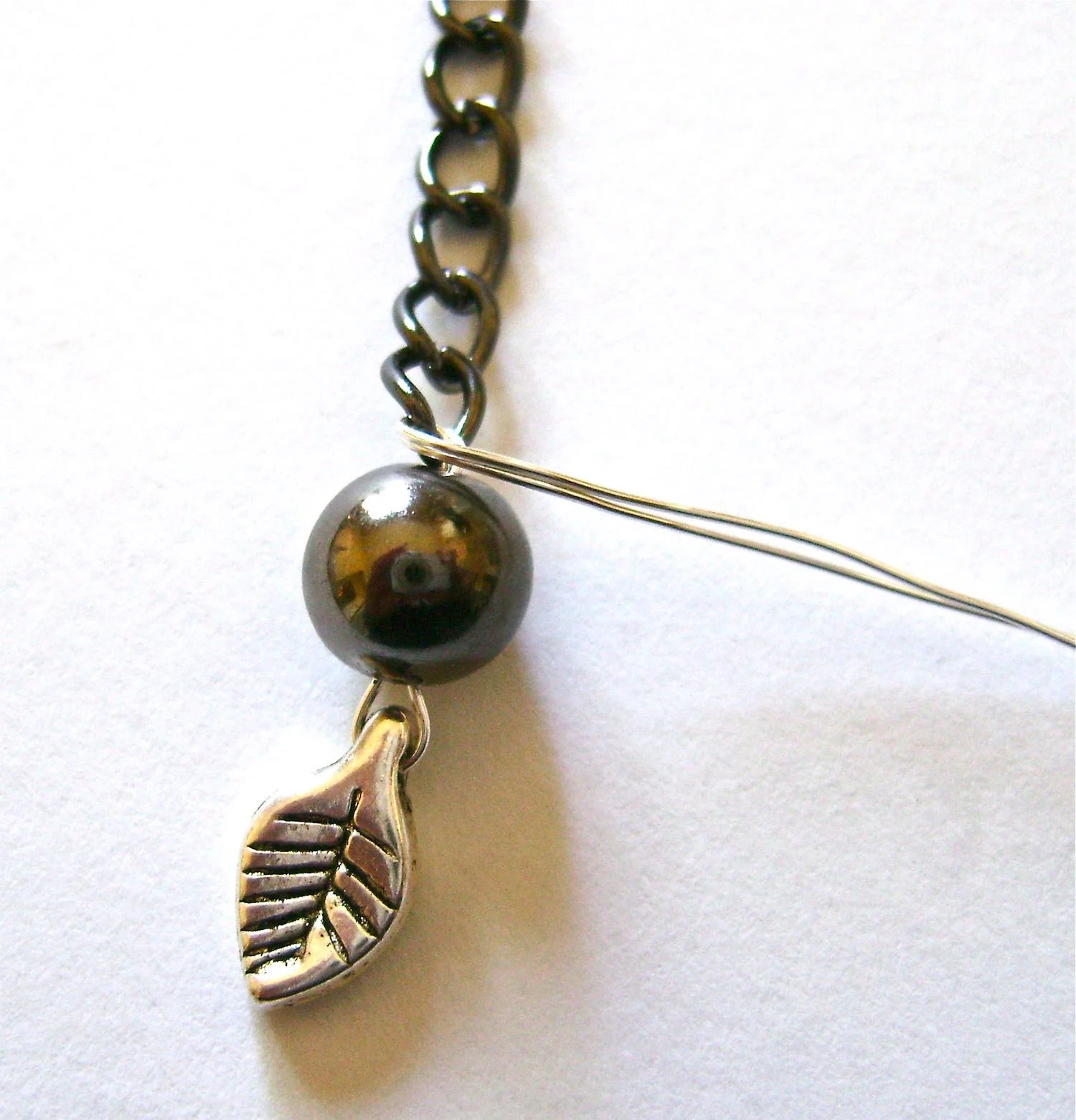 step 5 - Bend the wires together, across the top of the pearl and wind them around 4 or 5 times between the pearl and chain.