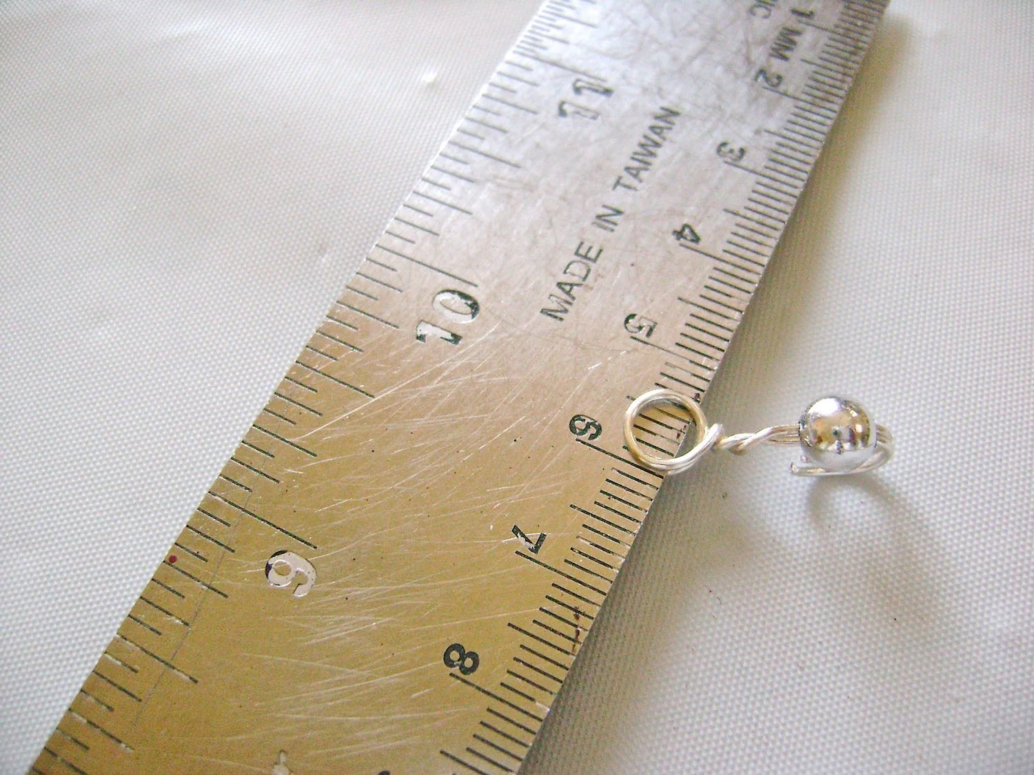 step 5 - Slip a metal ruler or other thin flat object between the two loops and wiggle the ruler from left to right to separate the loops.
