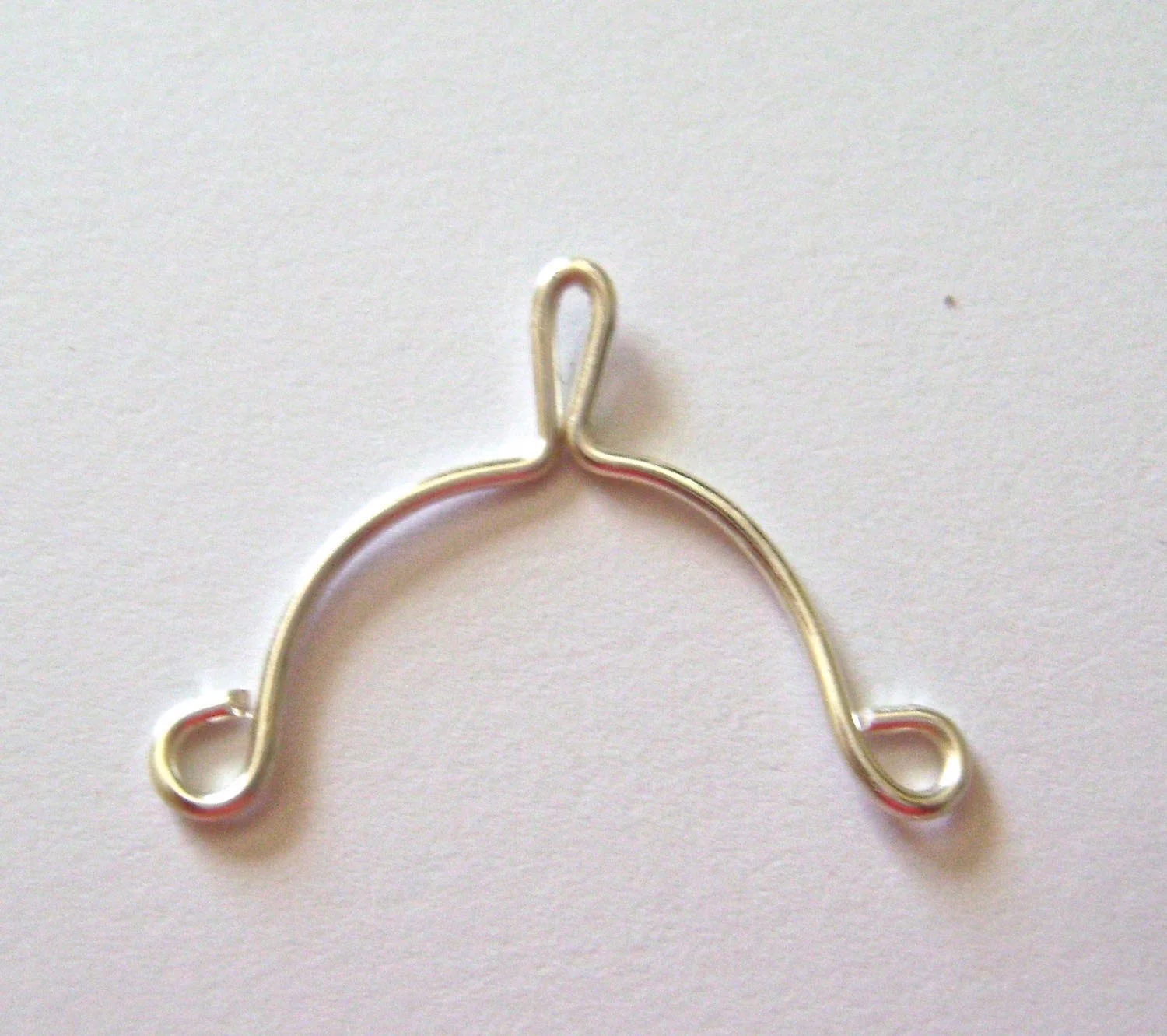 step 3 - Smooth each side of the wire over a round object to create matching arches.