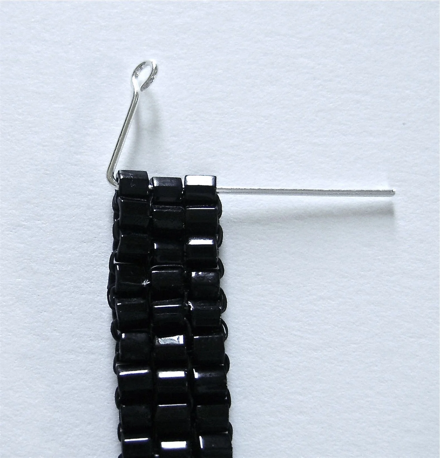 step 12 - Put the straight end of the wire through the top three black beads.