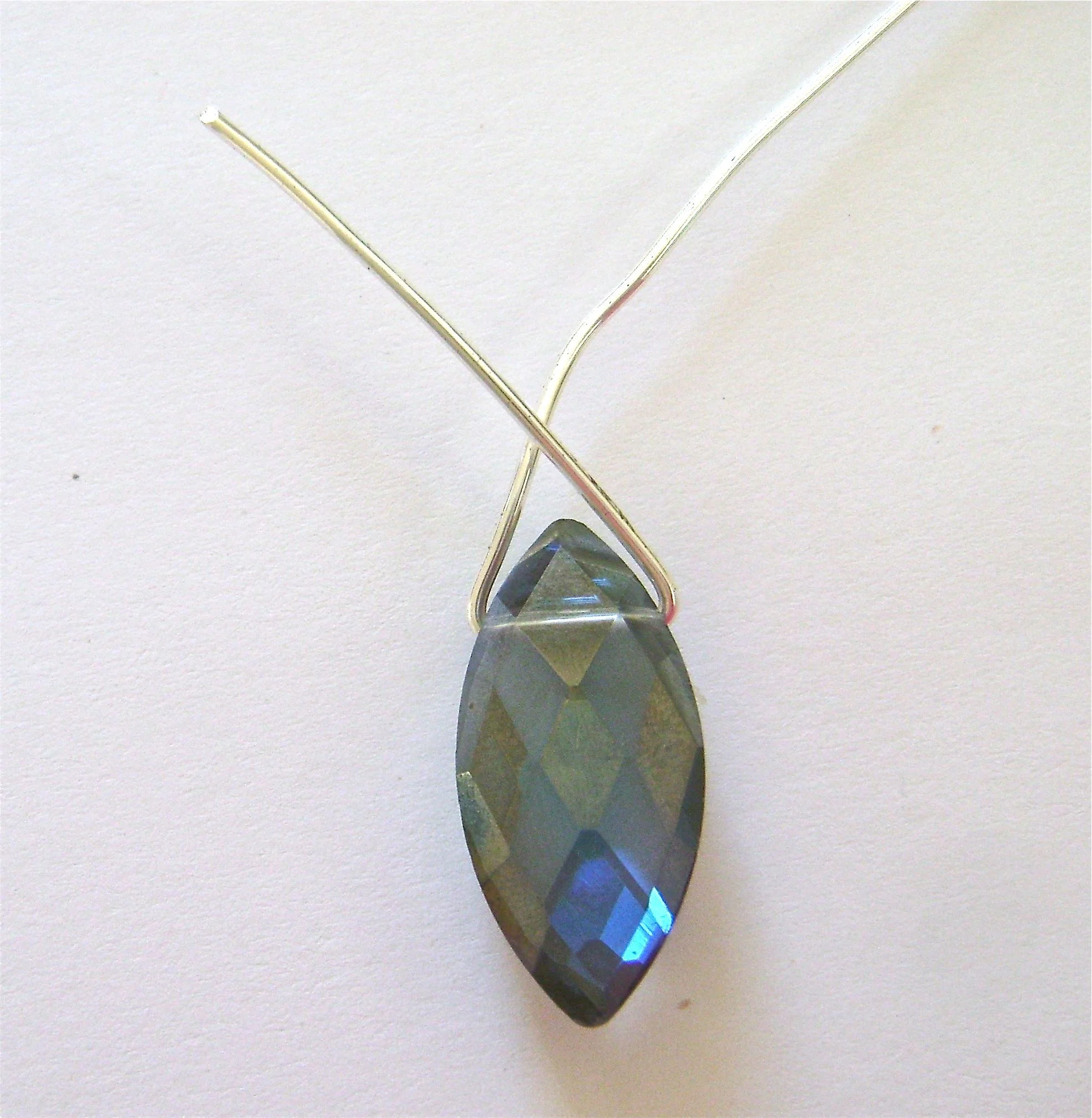 step 1 - Cut a three inch piece of wire. Slip it into the hole in the bead. Bend the wire on both sides of the bead up to meet each other.