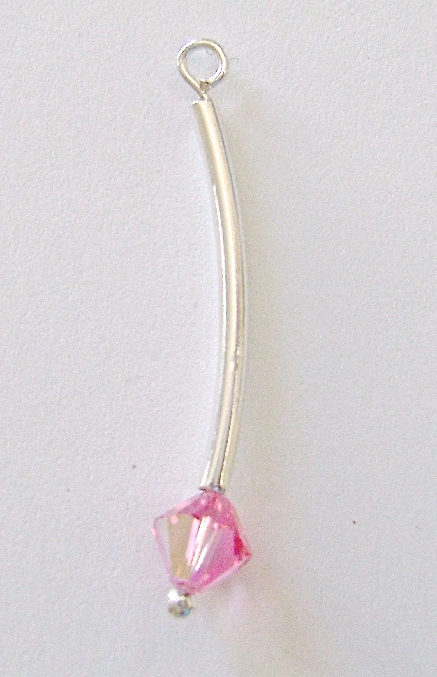 step 4 - Using round nose pliers, create a loop with the wire and remove the excess with wire cutters. The loop should be straight above the curved tube.
