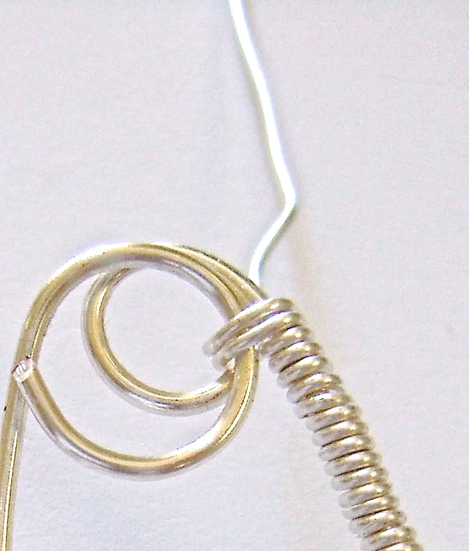 step 10 - Be sure to wrap around the raw edges of the 5” wire to conceal them. If necessary, trim excess wire from the small loop end. Stop wrapping 1/4” from the center top of the earring. Cut off excess wire and smooth the end with pliers.
