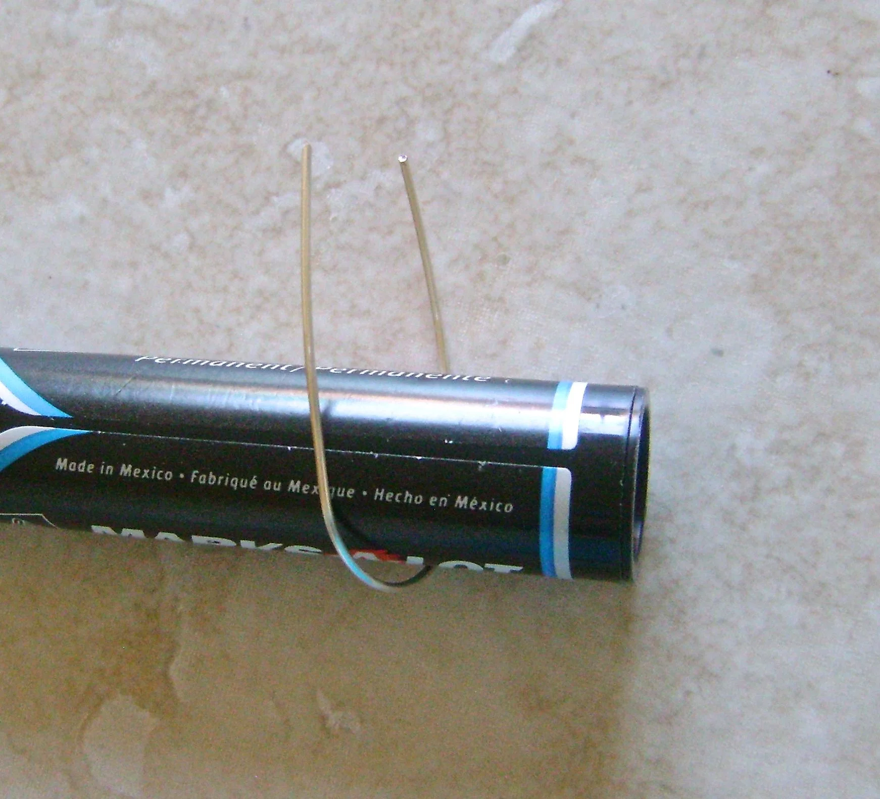step 2 - Place the fat end of a magic marker in the middle of the wire and bend both sides up to form a smooth curve.