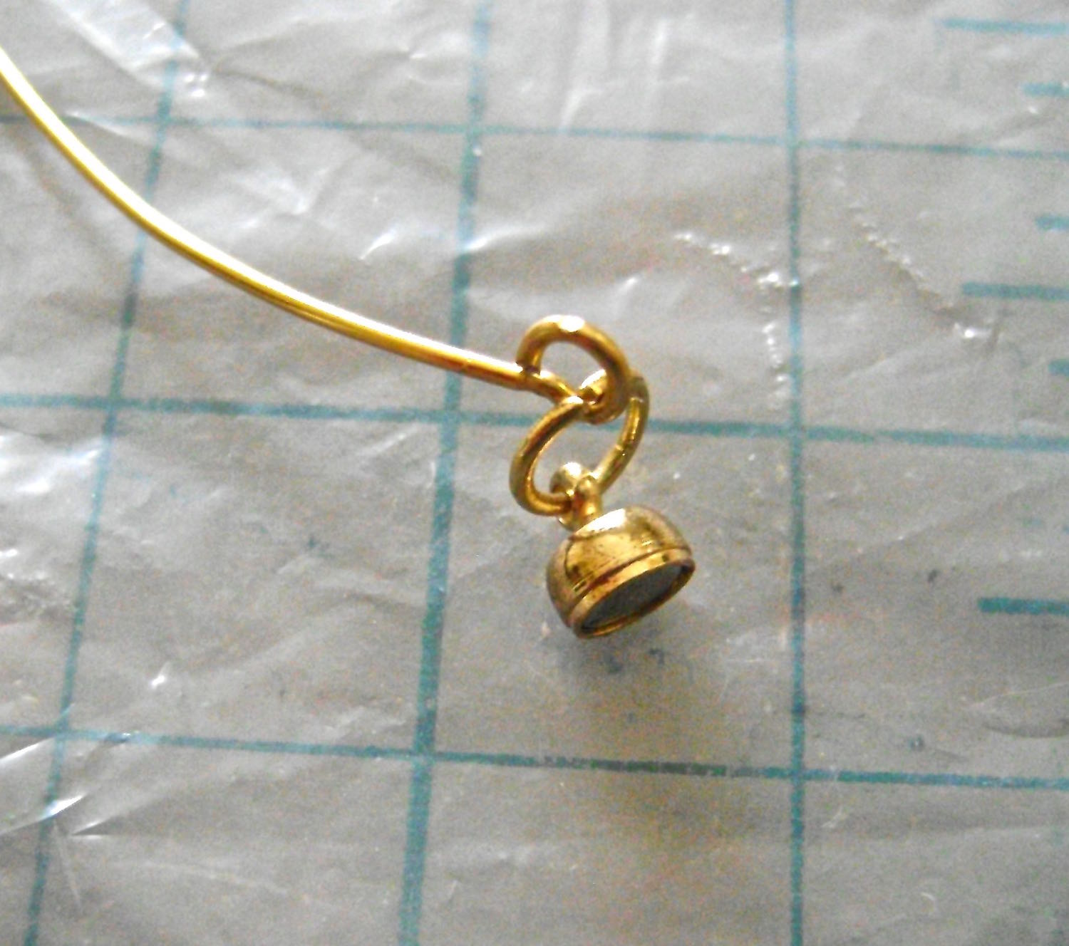 step 15 - Make a loop on one end of the wire and attach a jump ring and one side of a magnetic clasp. Slide the pendant onto the other end and finish the necklace with a loop, jump ring and clasp.
