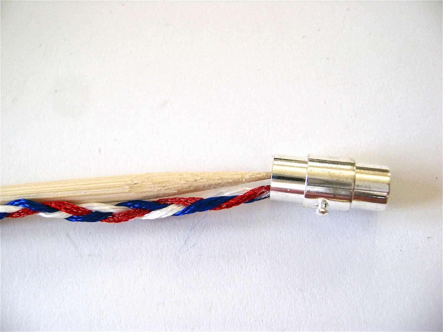 step 9 - Trim the ends of the floss near the knots. Use a wooden pick to apply a gob of E-6000 glue into the end of the clasp. Use the pick to stuff the knot inside. Attach the clasp to the other end of the braid in the same way. Let it dry overnight.