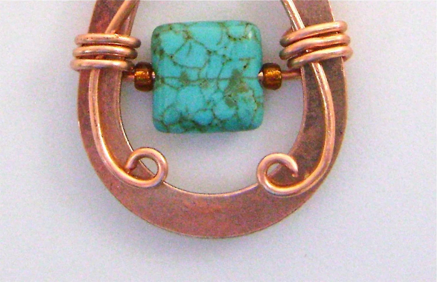 step 6 - Cut the 4” wire ends to identical lengths. Curl the ends toward the center of the teardrop with round nose pliers.