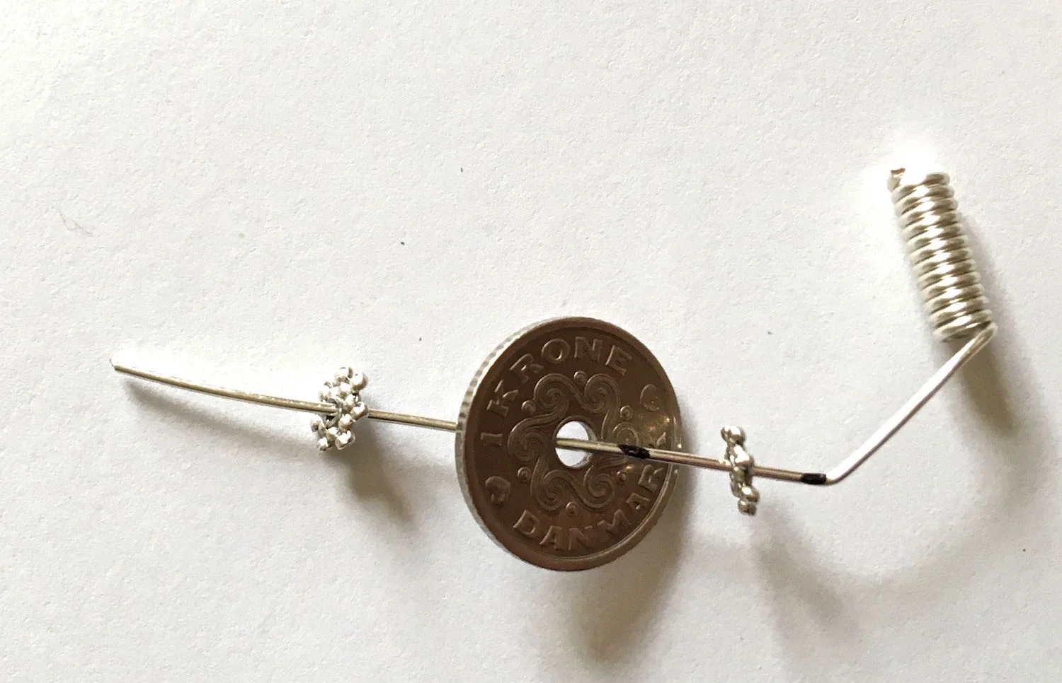 step 4 - Slip a flat spacer bead, a coin, and another spacer bead on the wire.
