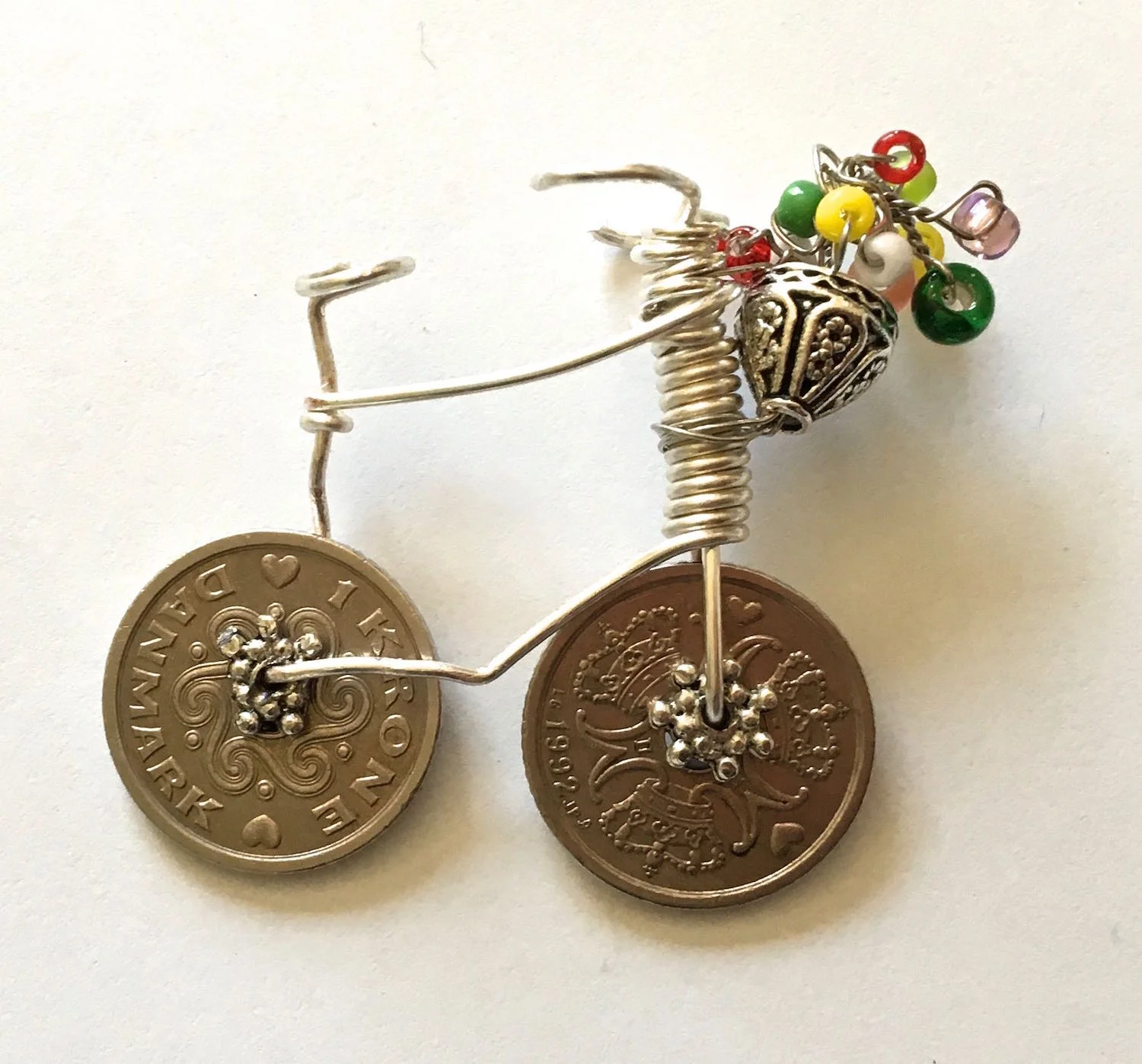 step 13 - Continue adding colorful beads of various sizes to the wire and twisting them to wrap the wire. When you’re happy with your collection of flowers, bend them into place to form an arrangement. Cut away the excess wire and tuck the end into the flowers.