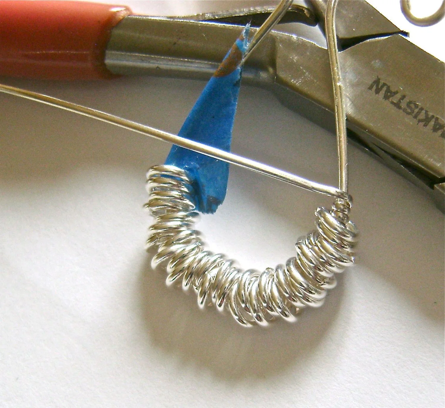 step 5 - Cut a piece of half round wire to measure 16”. Wrap the end around the untaped round wire twice. Bring the wire to the front of the work.