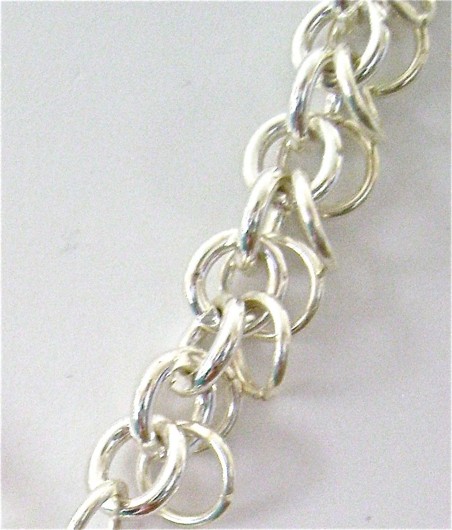 The Chain I attached an interesting chain to this pendant that I found at Michaels. When I got the chain home from the store, I examined it closely to see how it was made and discovered I could have done this myself. The core is simply 5mm jump rings in what I’m guessing is 14 gauge. To make the chain, attach the 14 gauge rings to each other to create the length you need. Then attach a 5mm 18 gauge ring to each of the 14 gauge rings.