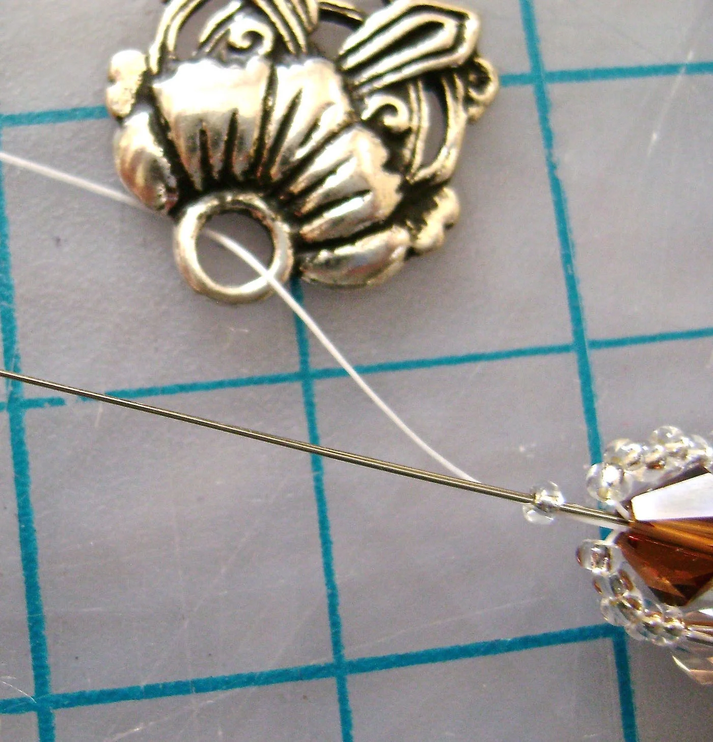step 9 - Add one half of the clasp of your choice, then bring the needle back through the seed bead and up through the next two 6MM beads.