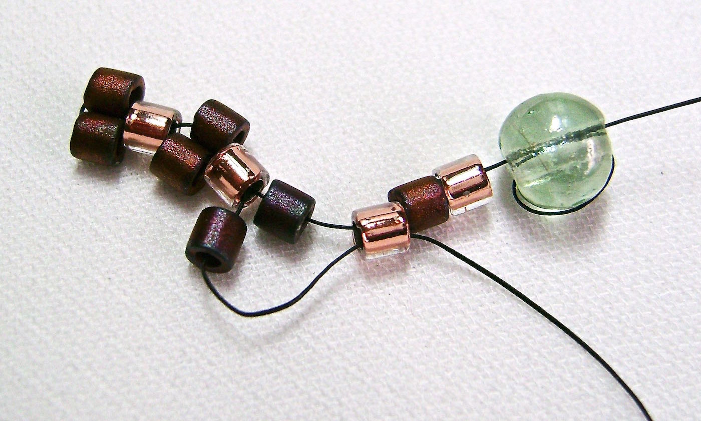 step 5 - Add another dark bead and pass through the third light bead.