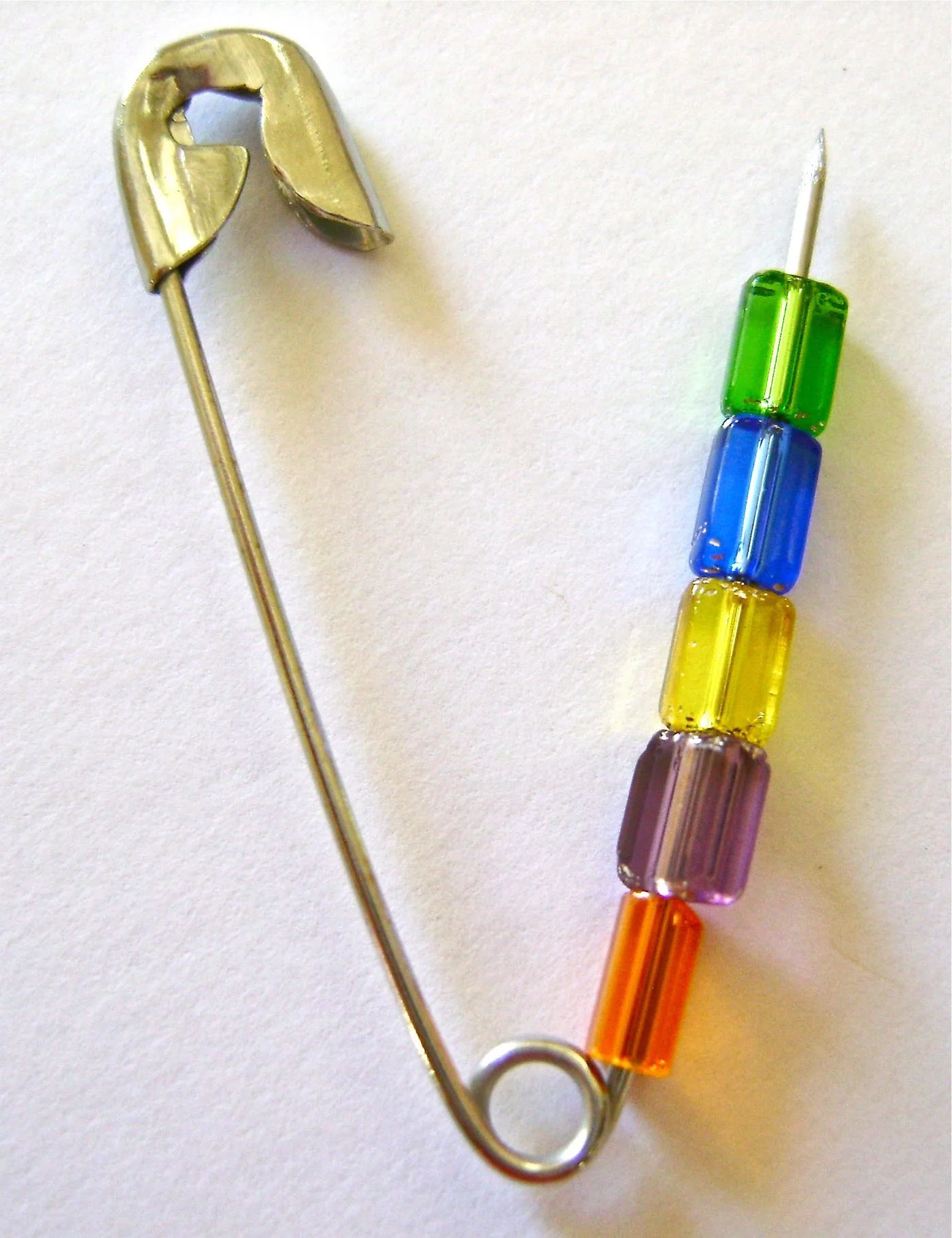 step 1 - Open 50 safety pins and thread 5 beads onto each. Change the order of the colors as you add them to create a variety of color patterns. Close the pins.