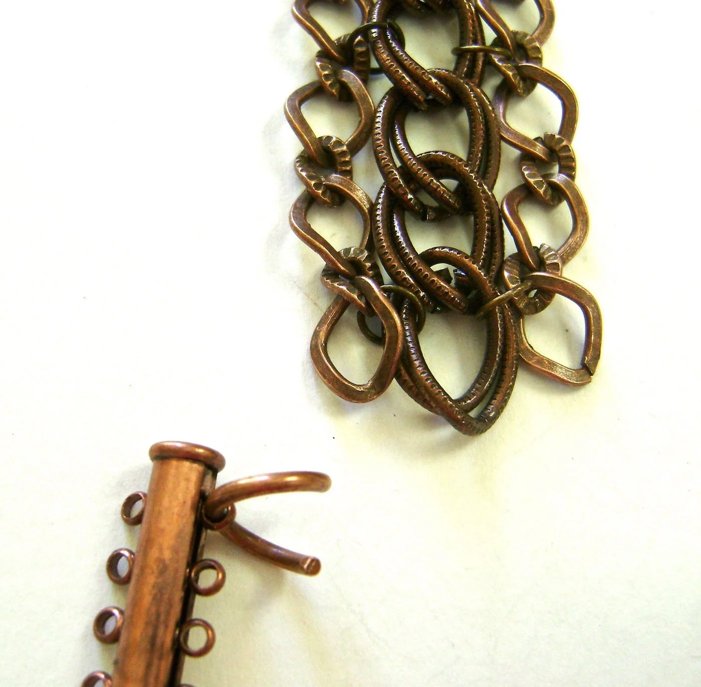 step 2 - Connect the heavy jump ring that came with the chains, to one hole in the clasp. As an alternative you can also use a link in the chain for the connection.