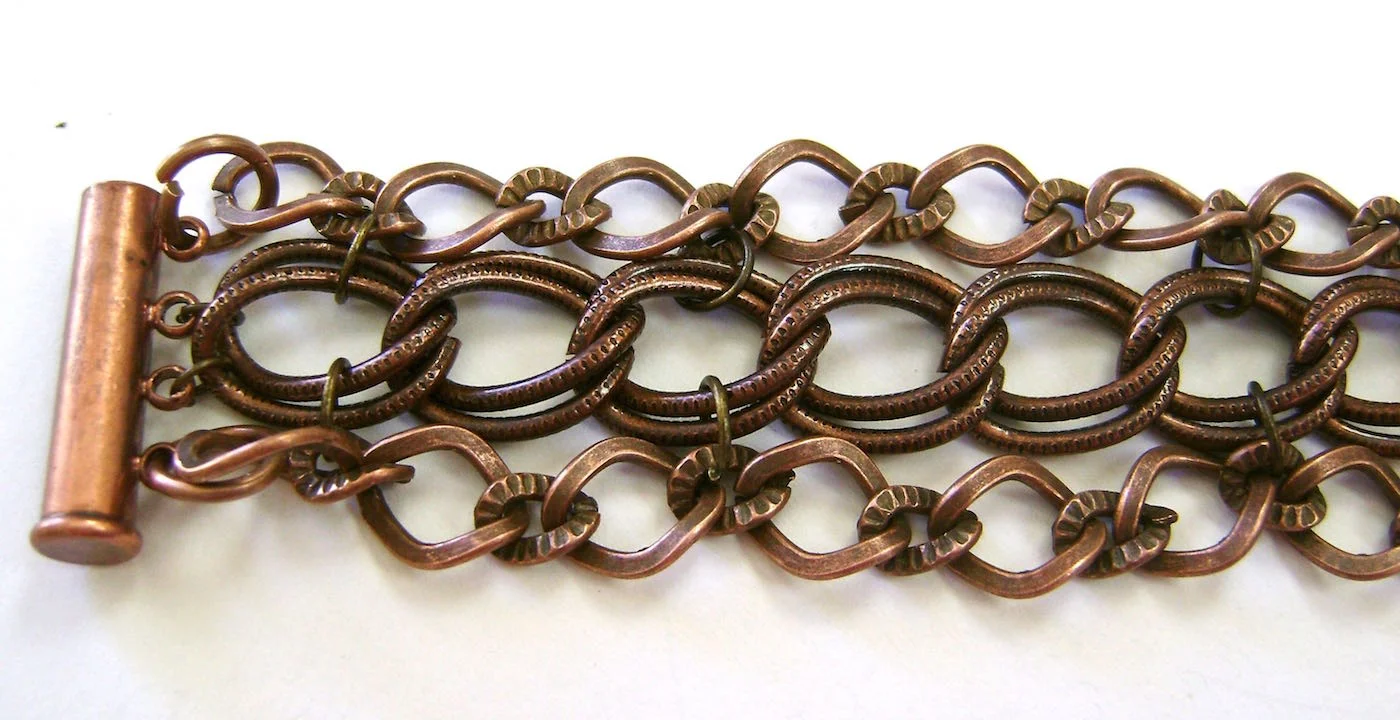 step 4 - Use small purchased jump rings to connect the large double links to the two center holes of the clasp. Follow the same steps to attach the clasp to the other end of the chains.