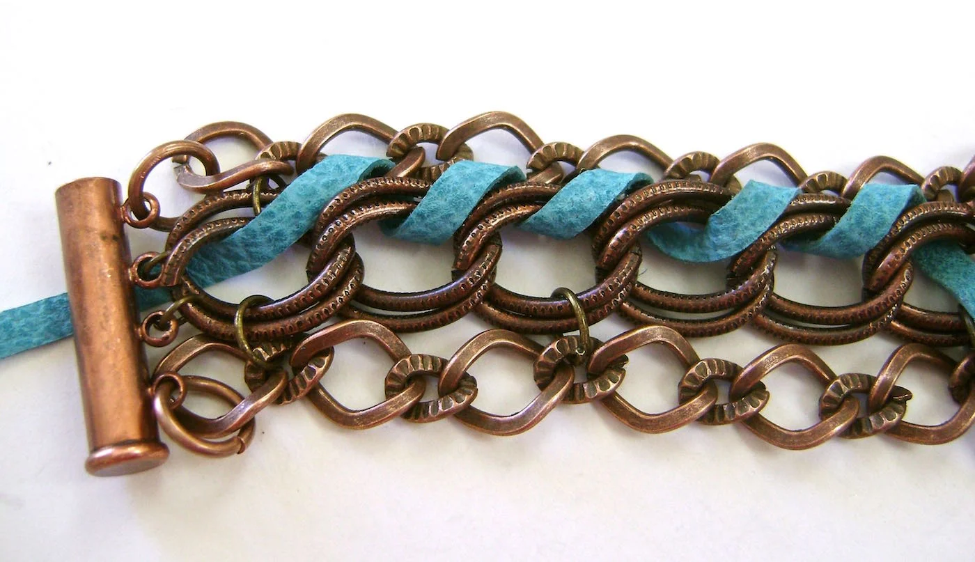 step 5 - Leave a 6” tail and weave the suede through the chain to hold the small chain and large middle chain together. When you reach the end, weave through the end links to move the lace to the other side. Weave across the other side.
