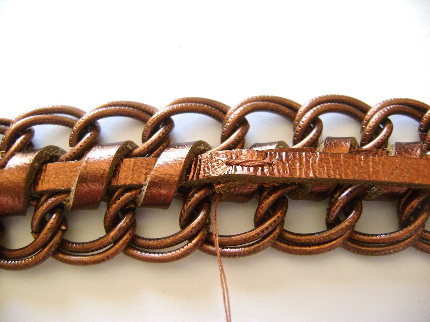 step 4 - Overlap the two tails and sew them together with needle and thread. Cut off the excess leather.