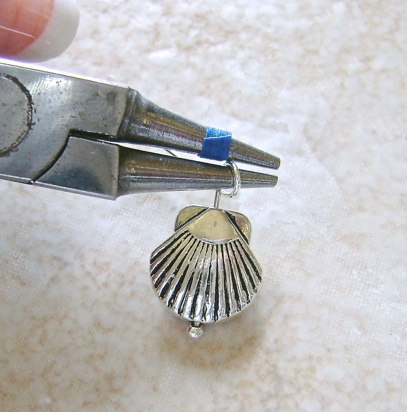 step 3 - Move the wire to the bottom of the pliers and complete the loop with the wire at the back of the pliers.