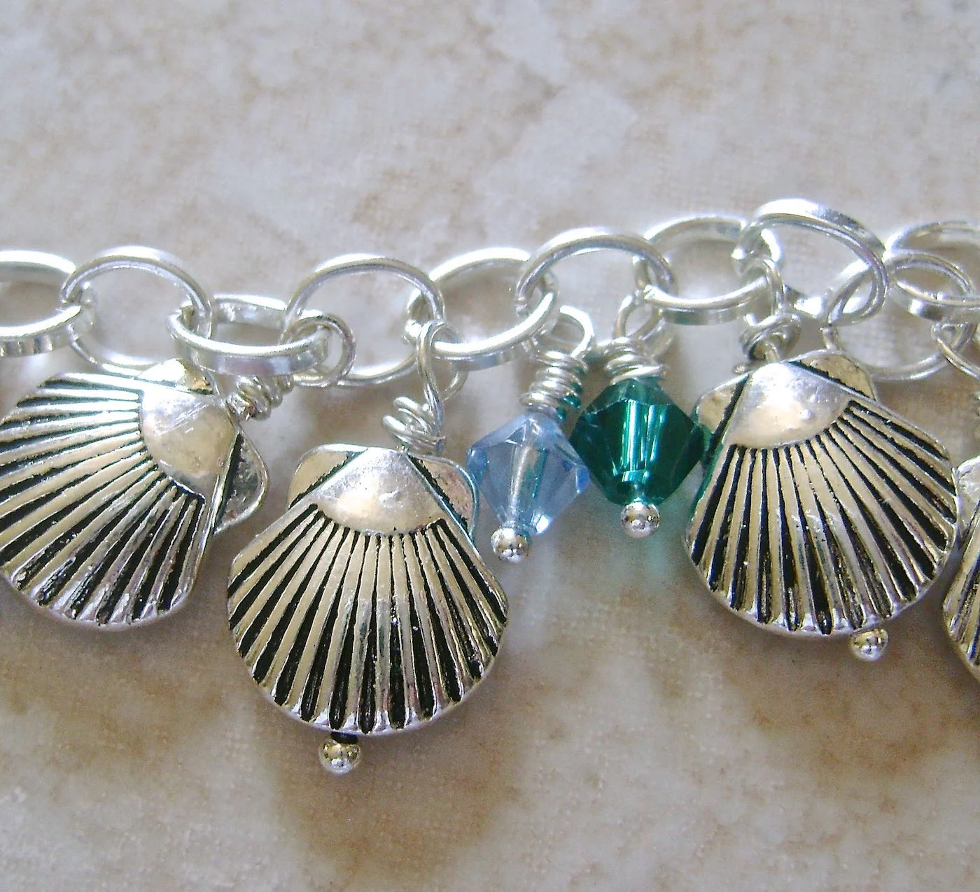 step 8 - Create wrapped loops for 13 teal and 13 blue crystals. Open the empty chain link between the shells and attach one of each color crystal.