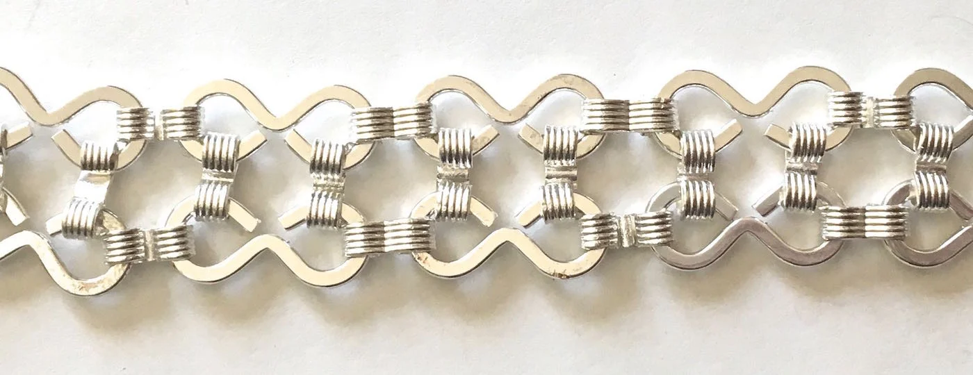 If you don’t, you may make the mistake I did. I didn’t notice which way the closed side of the eight was facing on each piece and my first strands (photo 1) had them facing in different directions. I had to relink all the pieces. The closed side of the eight should be on the outer edge of the bracelet. Also, close all the links on the back of the bracelet not the front.