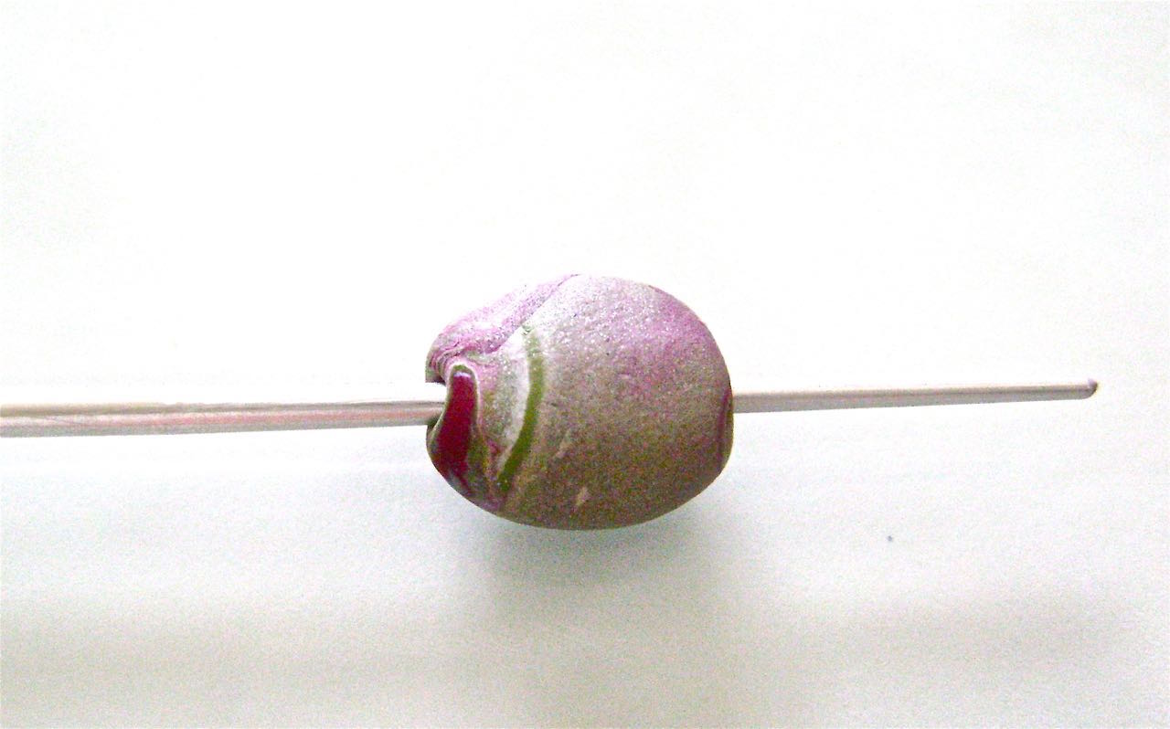 step 5 - Create holes in the beads by first lightly piercing one side with the narrow end of an Etch ‘N Pearl tool. Remove the tool and bring it to the other side. With a gentle turning motion, move the tool through the bead and out the pierced end.