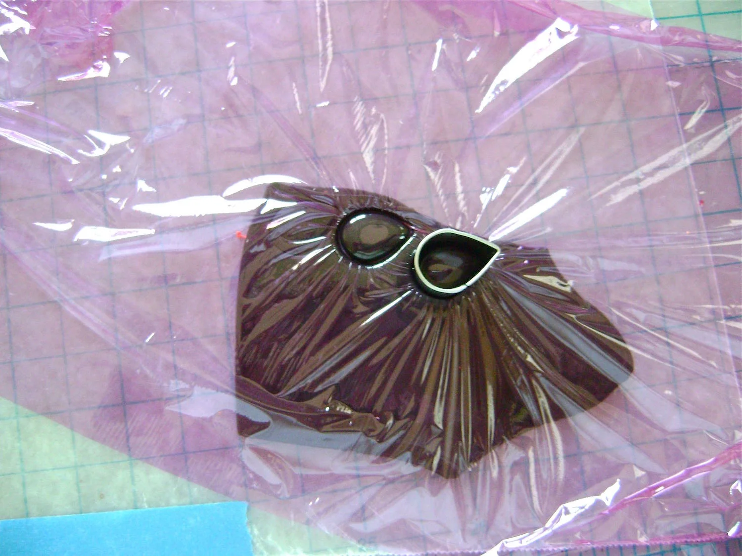 step 2 - Condition and roll out the black clay. Place kitchen plastic wrap over the clay. Use the .75” teardrop shaped clay cutter to form the watermelon seeds. I used 18 seeds on each napkin rings.