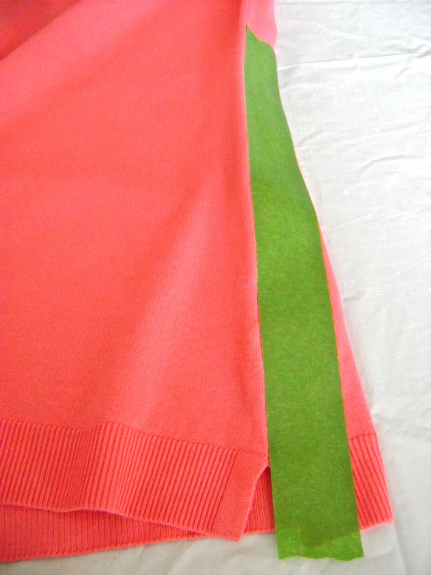 step 4 - Be sure to cover any parts of the sweater that should not receive paint. Place masking tape on the side seams on the back panel of the sweater.