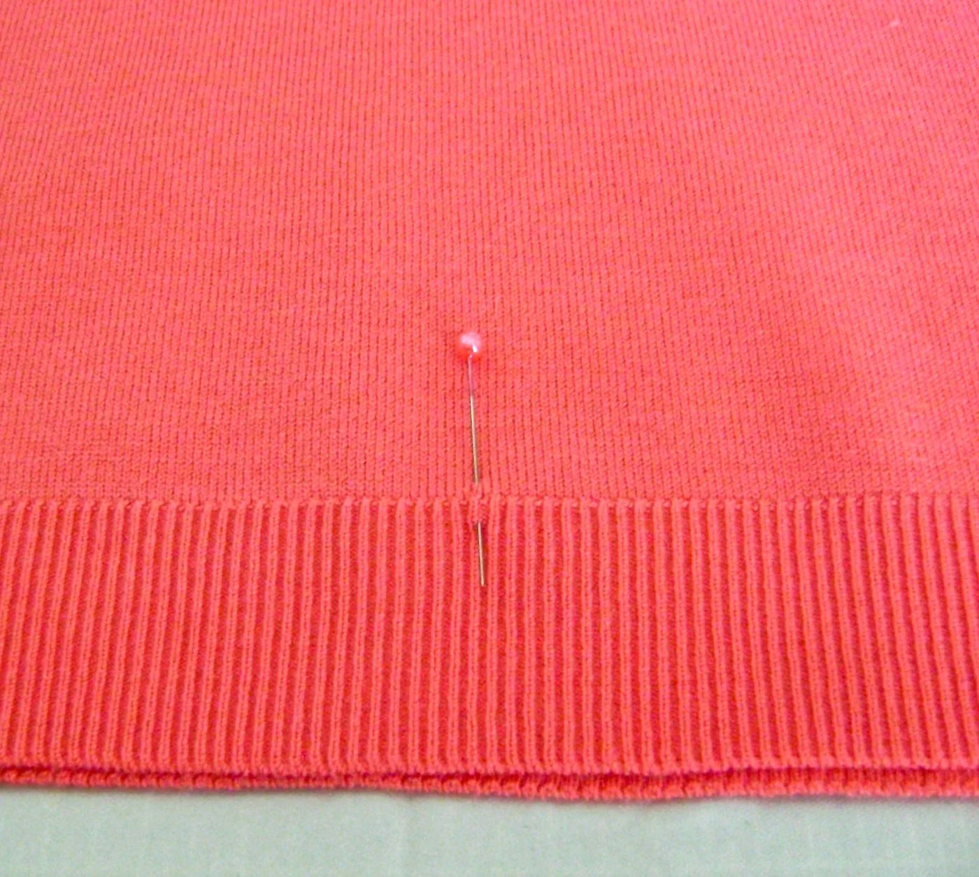 step 5 - Spray the back of the joined stencil pages with adhesive. Mark the center of the sweater with a pin or tape and position the center of the stencil over it. 