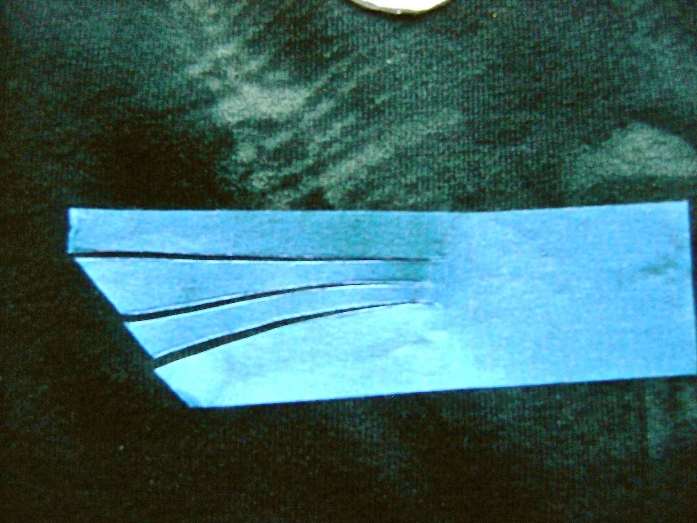 step 10 - Lightly press the tape in place on the face. As you do, separate the cut pieces so there is merely a hairline space between them. Cover all areas outside the tape, then spray with Malt Shop paint. When dry, remove the tape. You can use Black Tie paint to shape the face even more if you choose. The black will cover up the light paint.