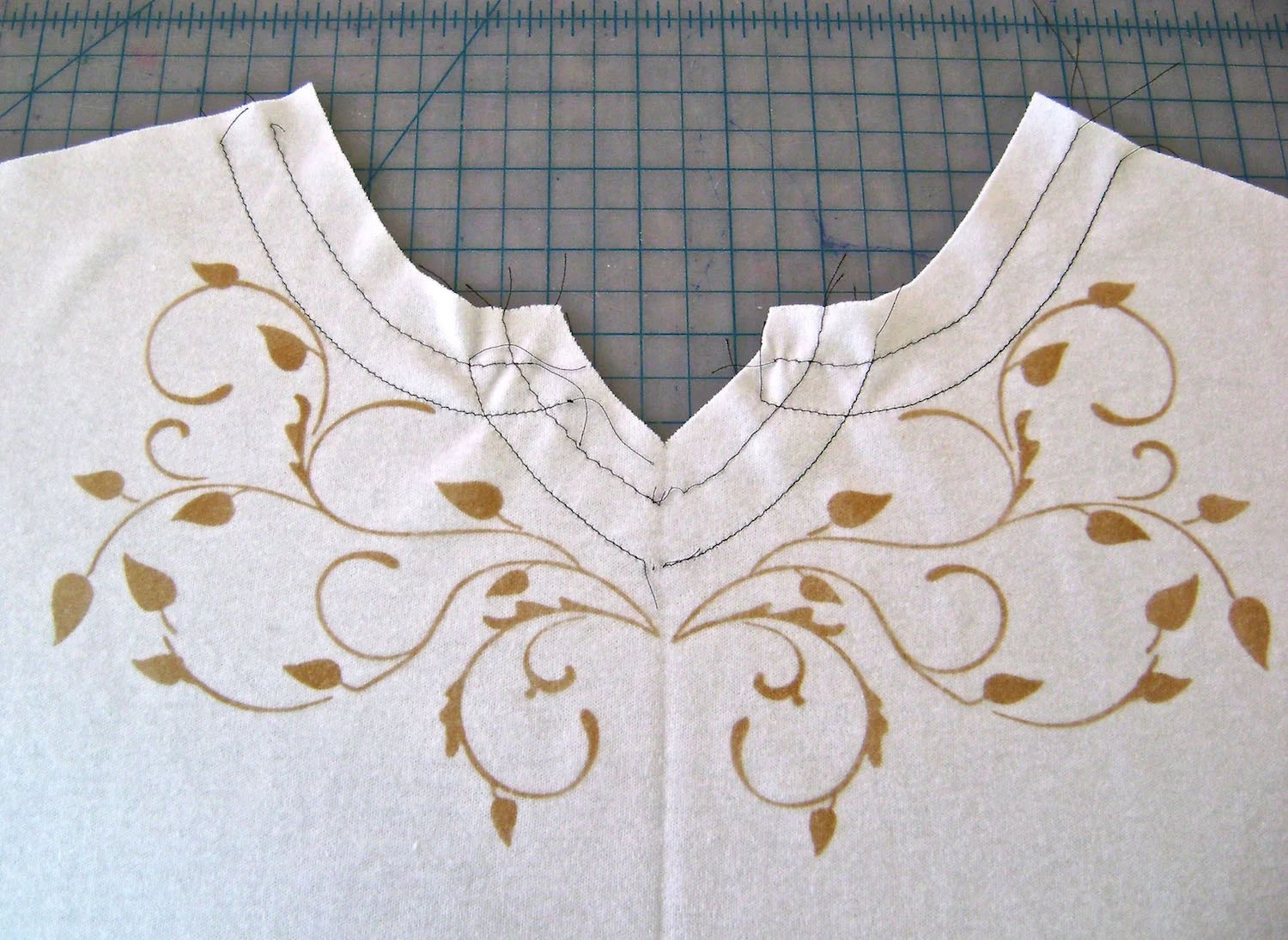 step 7 - Remove paint from the stencil then apply adhesive spray. Repeat step #4 and # 5 with the stencil flipped to create a mirror image of the painted fabric.