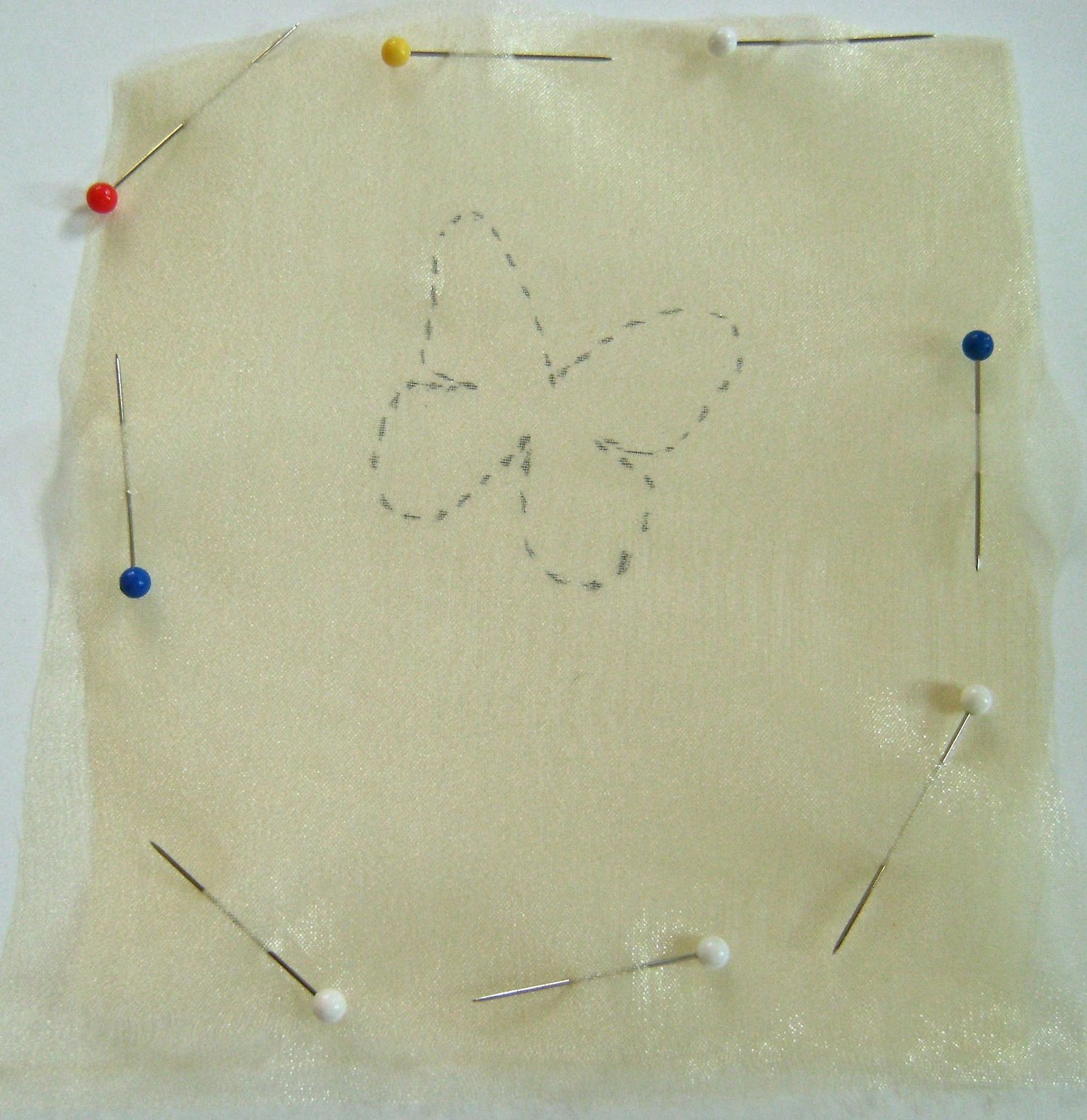step 15 - Remove the fabric from the paper and pin the squares together. Each butterfly is made of two layers of organza fabric sewed together.