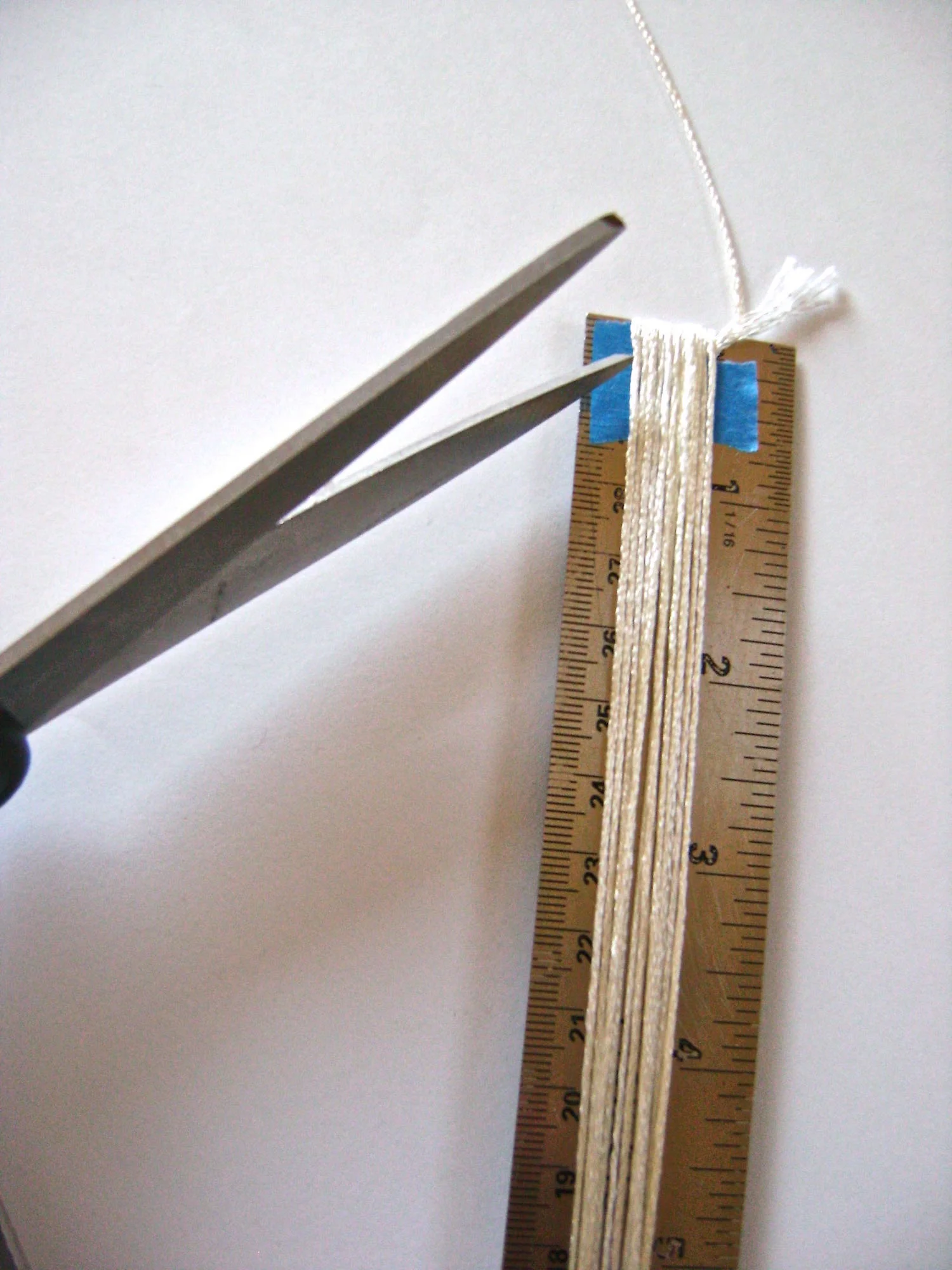 step 2 - Bend the ruler slightly to insert scissors under the floss. Cut both ends.