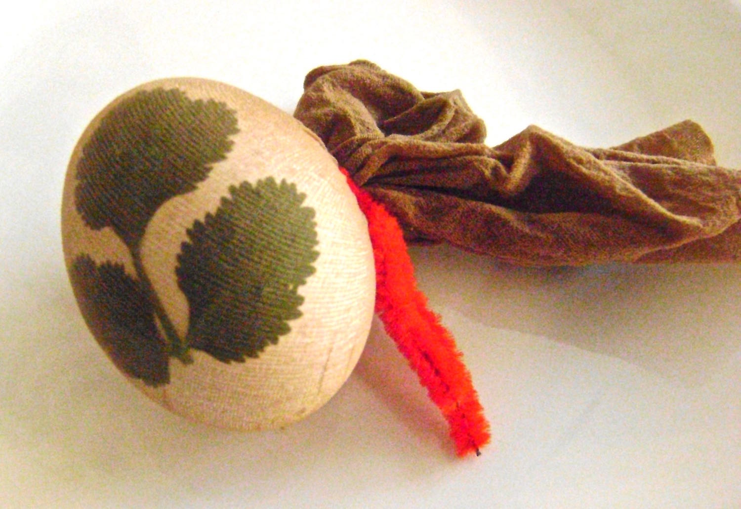 step 2 - Stuff the egg into a portion of a knee high stocking. There are many ways to secure the stocking, like using rubber bands, string, etc. A pipe cleaner is one of the most practical tools for this job. After twisting it together, leave the ends long. 
