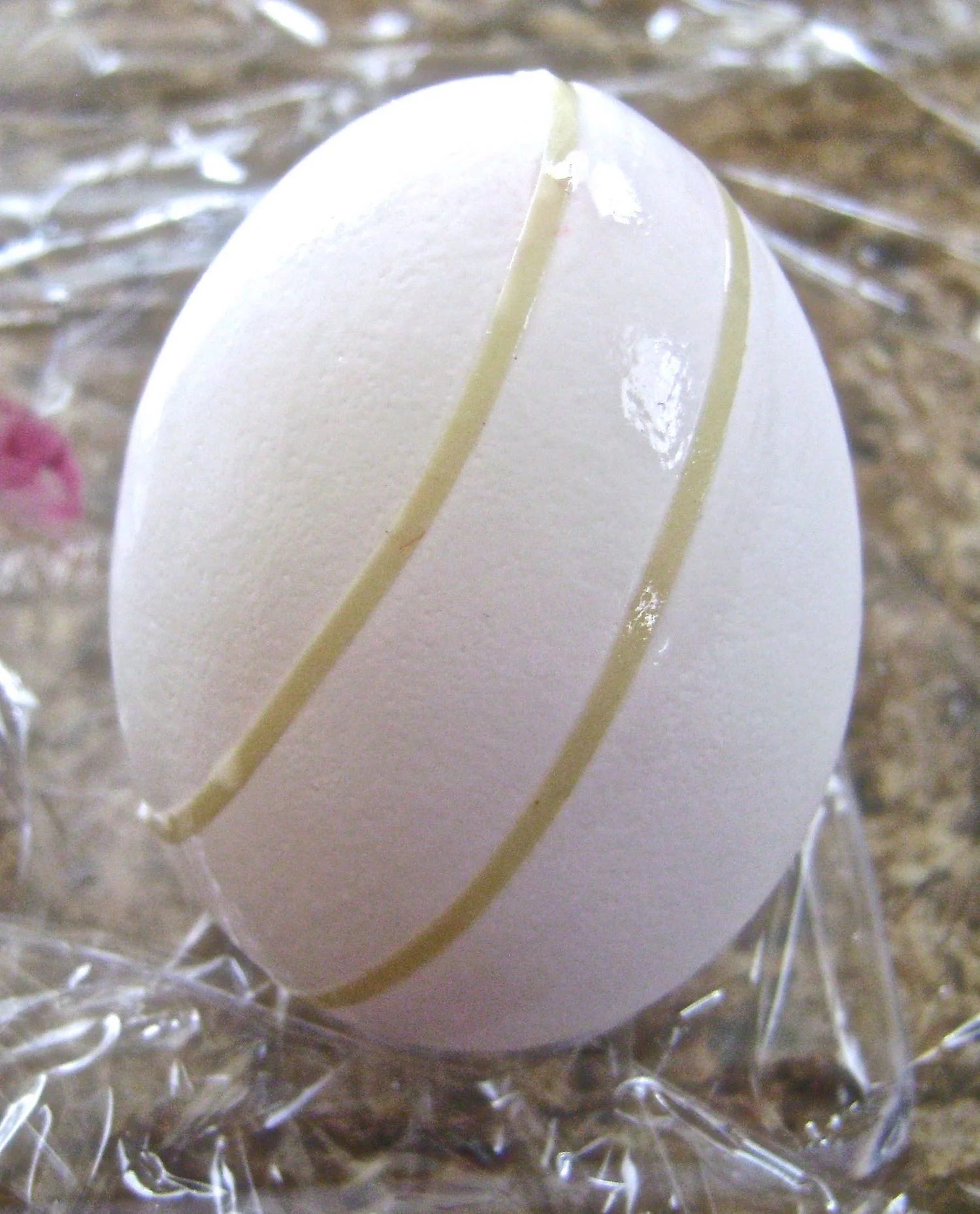 step 7A - Thin masking tape ( 1/8”) can help you achieve concepts and straight lines when it is applied to the egg shell. Use it to section off two colors or as a guide for painting with markers.