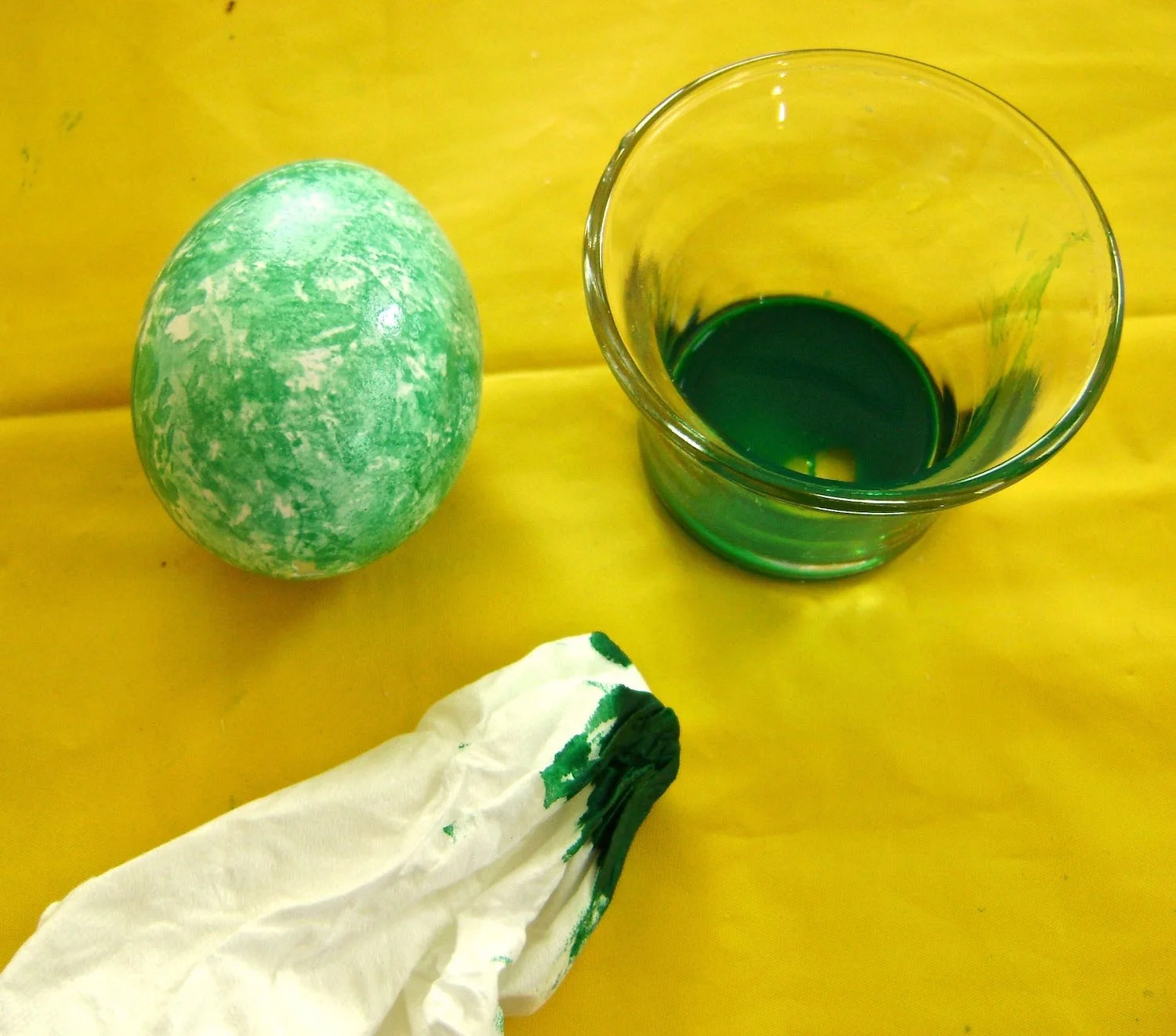 step 10 - Wad up a tissue and dip it in paint. Dab it lightly on a paper towel to collect excess paint and avoid puddles on the egg. Use the tissue to lightly dot color on the egg to create abstract designs. But don’t stop there! Apply other colors in the same way on top of the first.