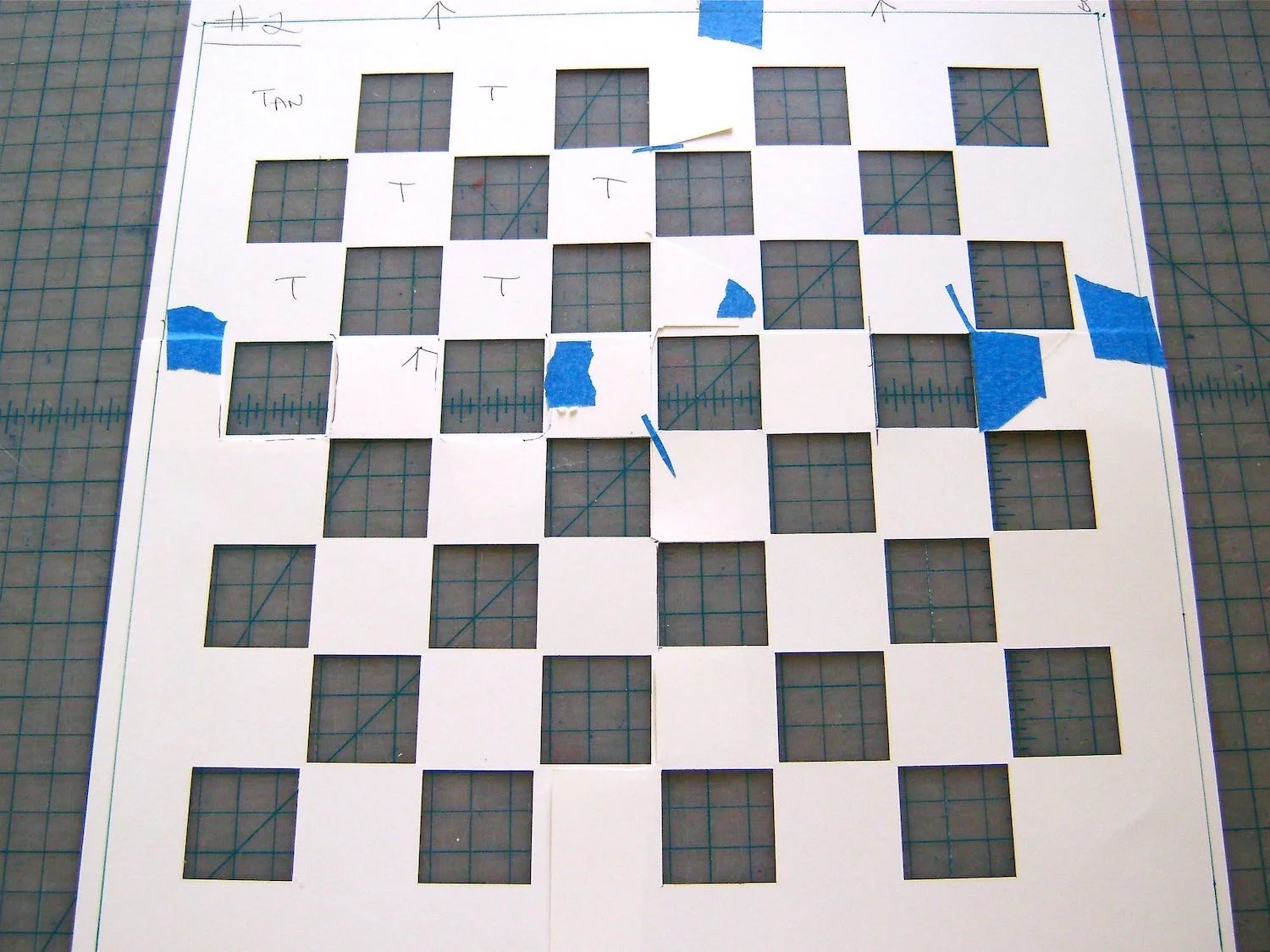 step 2 - Tape the copies together allowing a one-inch border on the four outer edges. The thin black lines indicate the edges of the playing board area. Once taped together, the playing area should measure 12” square. The complete card stock template should measure 14” square. With a craft knife and ruler, cut out all the black squares.