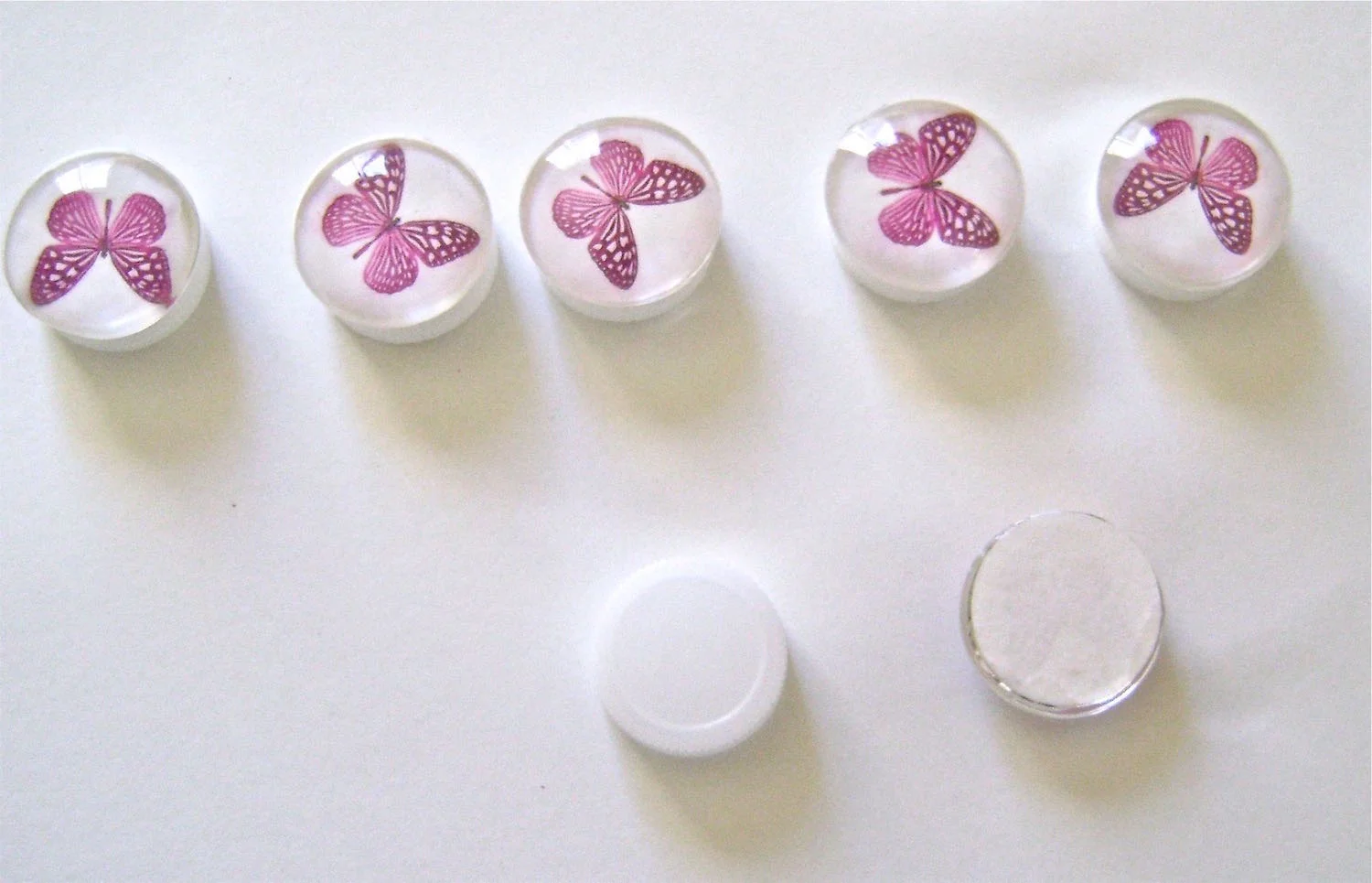 step 19 - Cut out the round printed images. Brush the flat side of a round glass piece with Decoupage. Immediately apply the image to the flat side of the glass. step 20 - Brush the flat side of a plastic water bottle cap with Dazzle-Tac and attach it to the blank side of the card stock. Dazzle-Tac won’t darken the card stock like some adhesives. Allow the checker pieces to dry completely before handling.