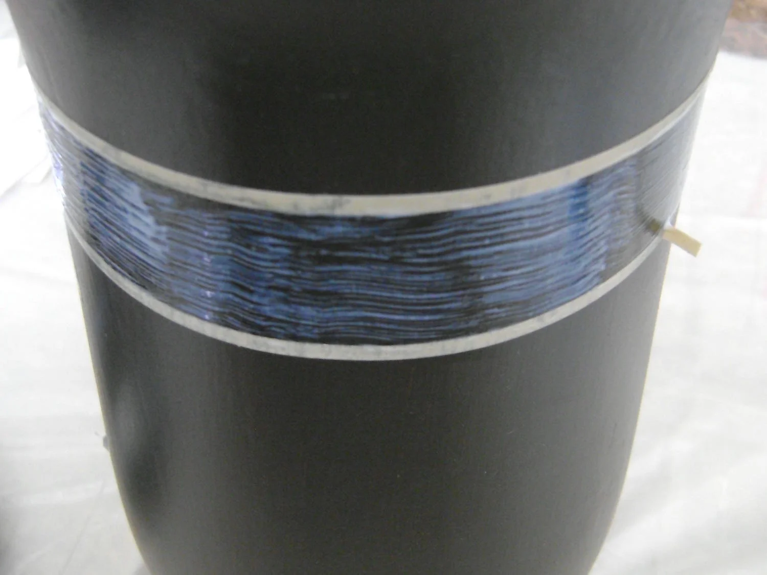 step 6 - Fill a container with Coat and Create. With a one-inch sponge brush, fill the space between the two tapes with the product, working around the entire vase. Also fill the top three stems that overlap the tape.
