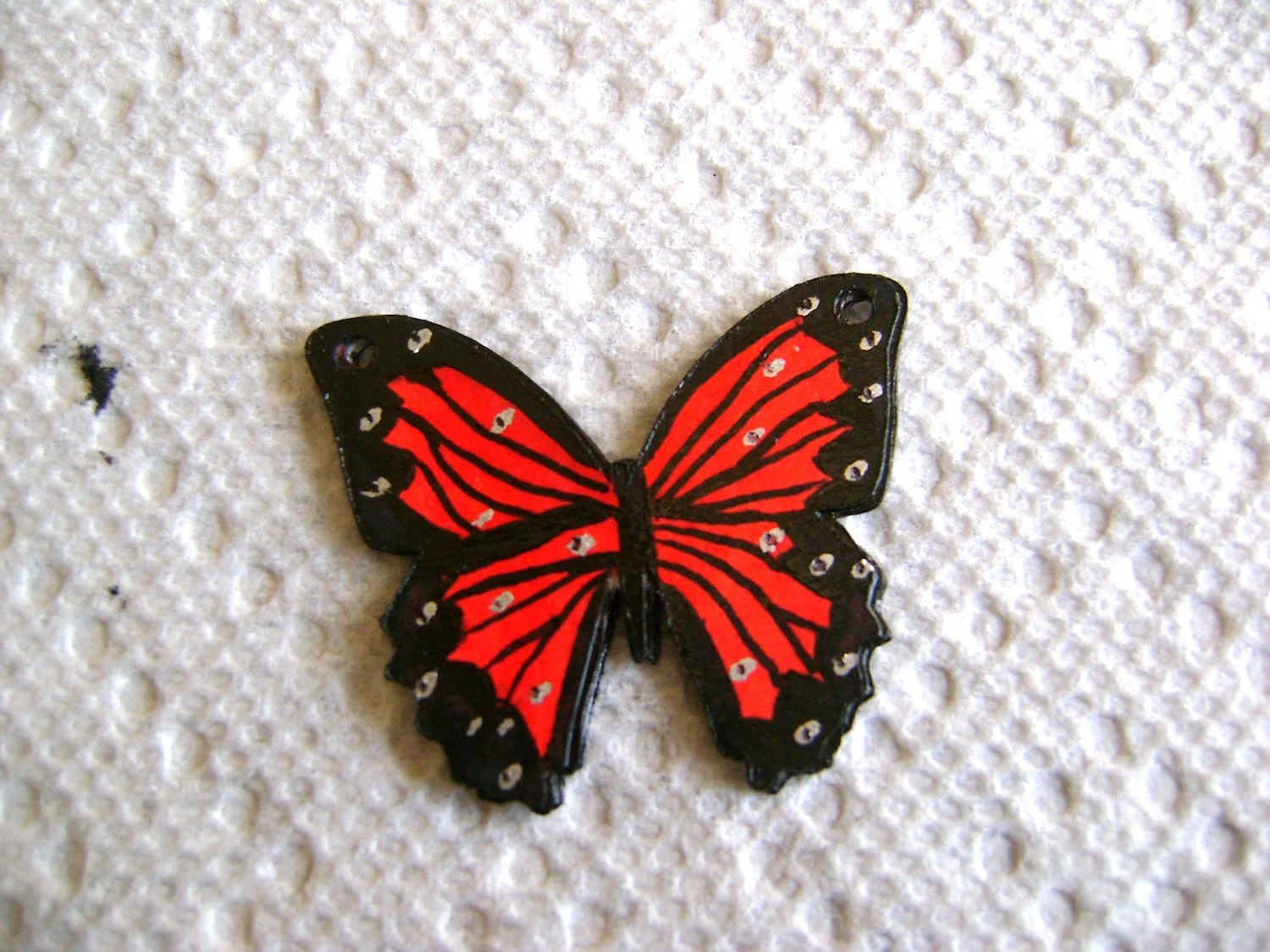 step 8 - Dot the black borders with the corner of the silver marker to create detail. Place a few more dots in the red areas. Dot the silver with the fine point black marker.