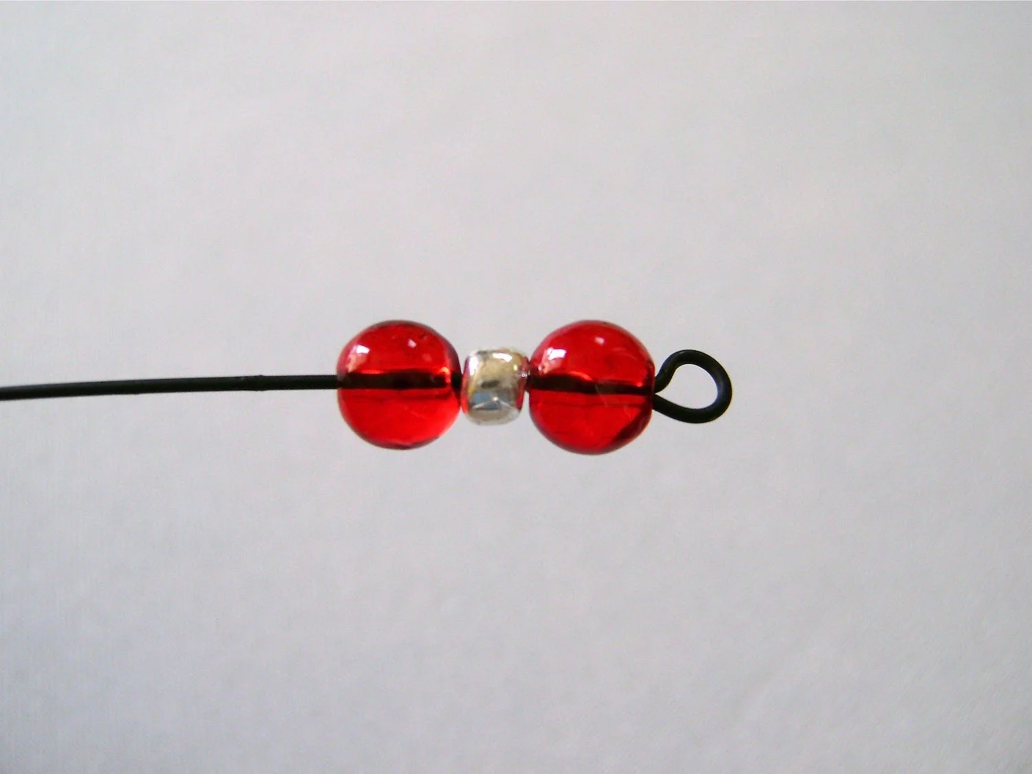 step 18 - Put a red, silver, and another red bead onto the wire.