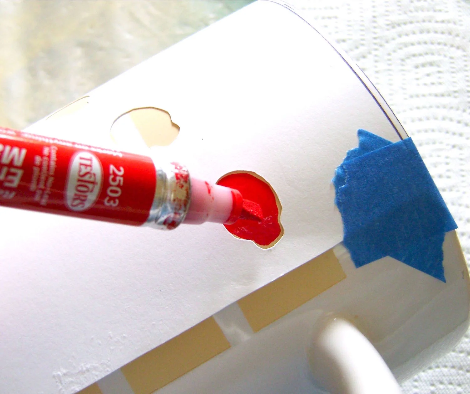 step 8 - Wrap the stencils around the mug with the bottom of the page aligned with the bottom of the mug. Use tape to hold it in place. Use a red marker to fill in the shapes. Leave a slight margin between the marker’s tip and the paper. If the paint touches the paper it may smear the red paint outside the borders of the shape.