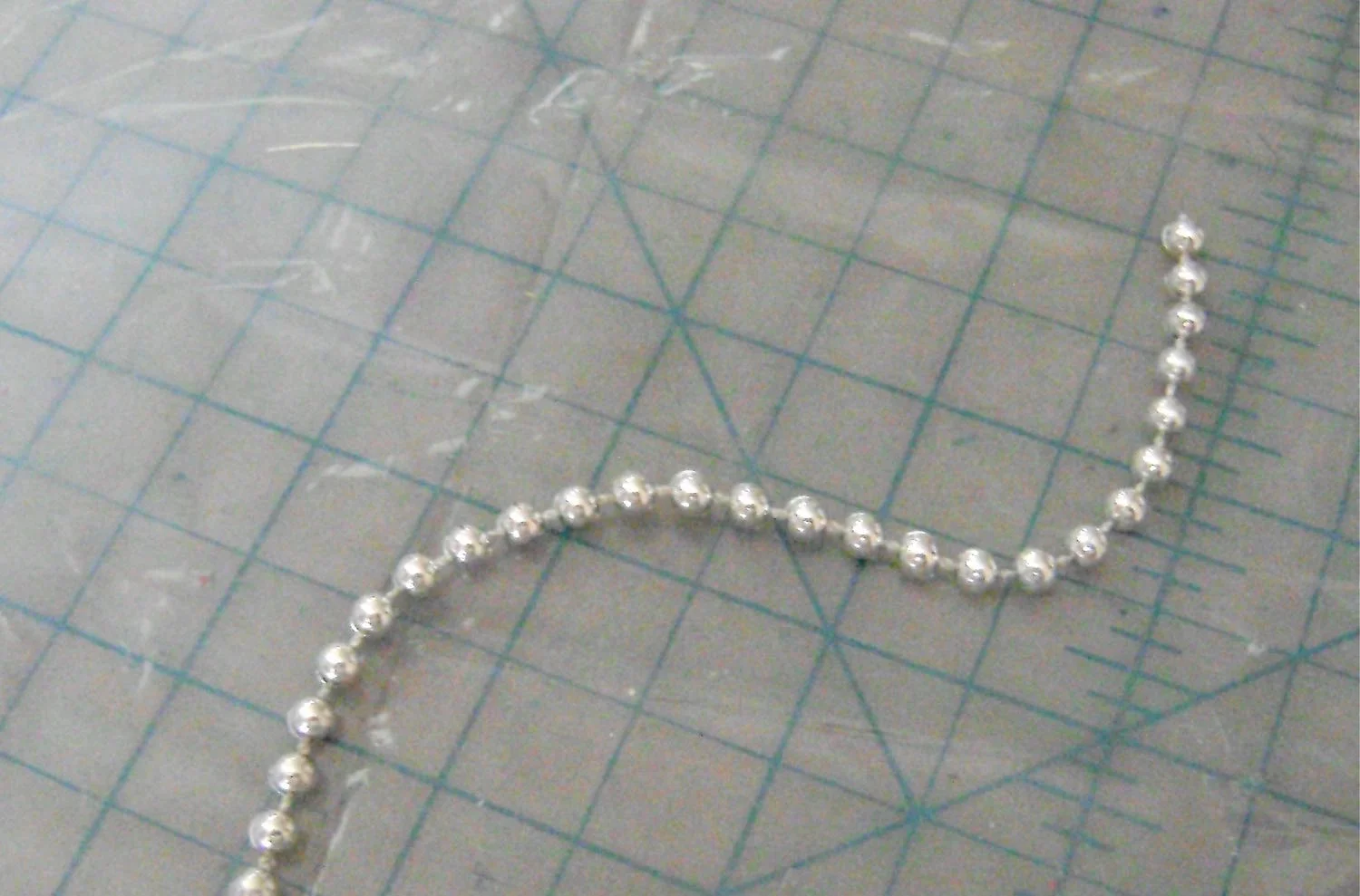 step 10 - Cut a strip of silver beads to fit around the center top of the parasol and glue it in place with Jewel-It.