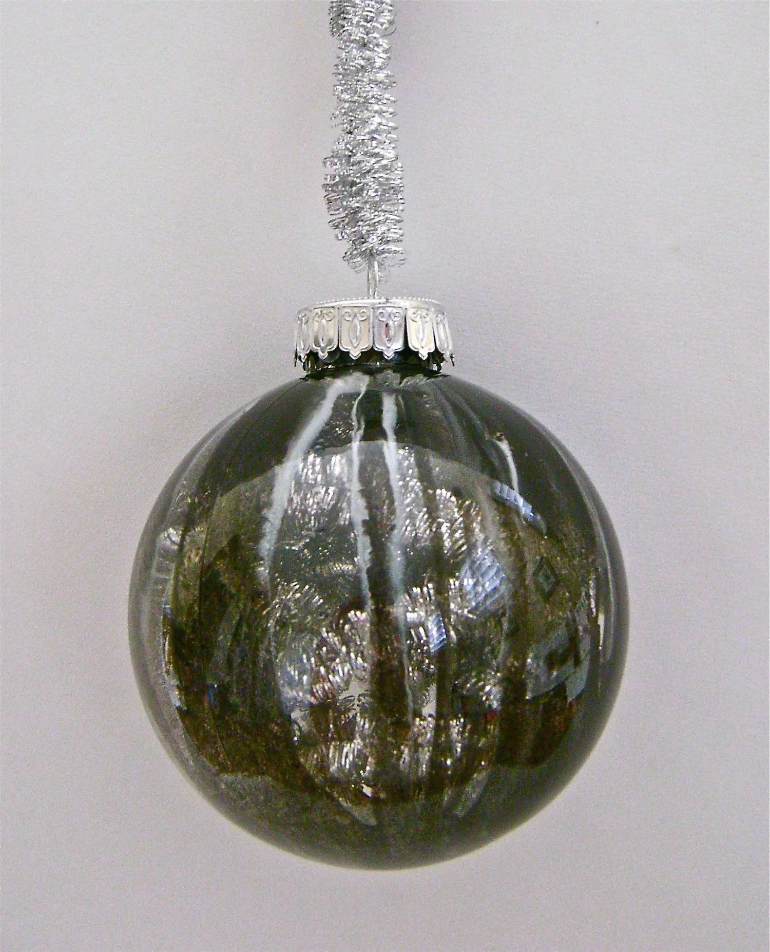 Black Ornament Apply black, silver and white paint, leaving large gaps between sections. When the paint is dry, fill the ornament with silver tinsel garland (the kind pictured for the ornament hanger).