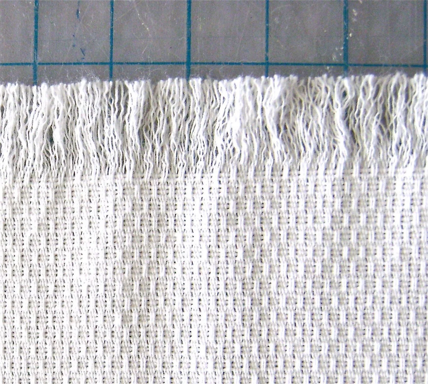step 2 - Continue to remove more threads until you have a half-inch of fringe. It’s unlikely that the section of fringe will be even so you will need to cut the ends to create a straight edge.